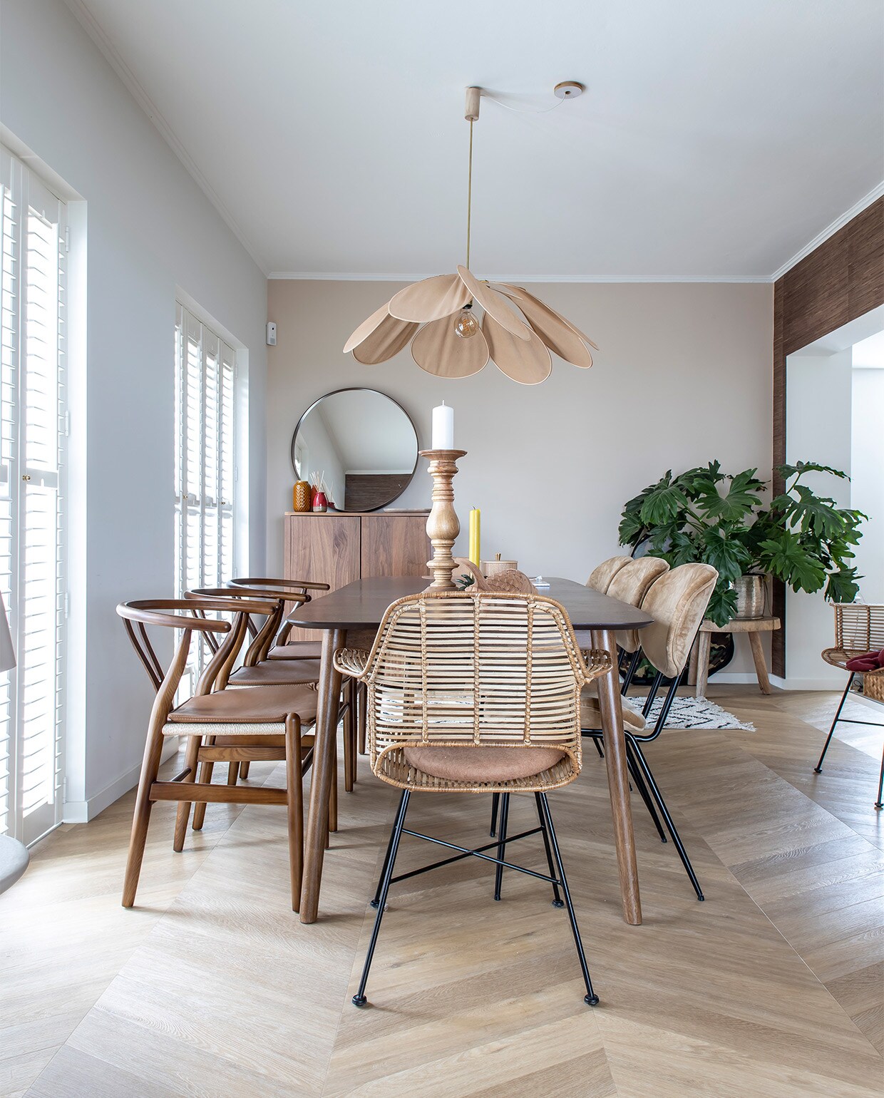 Muurkleur Flexa Gentle Umber. Behang Eijffinger Natural grasweefsel. Vloer Hongaarse punt pvc Therdex 6541. Houten stoelen Wishbone Chair, uitschuifbare tafel Sohome, gele kaars Sissy-Boy, kaarsenstandaard Loft Arnhem, rotan stoelen en drie stoelen rechts, rond kussen, kleed en plantentafel HKliving. Kast en spiegel Ikea Stockholm-lijn, vaasjes Zara home, lamp Archive Store. Shutters Veneta.