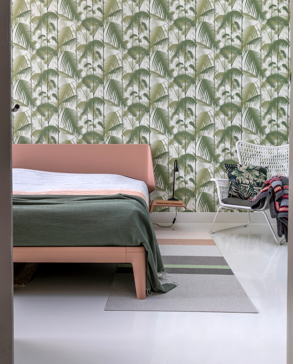 Behang Cole &amp; Son, bed Auping, dekbedovertrek Mae Engelgeer, vloerkleed Hay, stoel en bijzetlamp Ikea. Vloer witte epoxylak over oud laminaat. Overig herkomst onbekend.