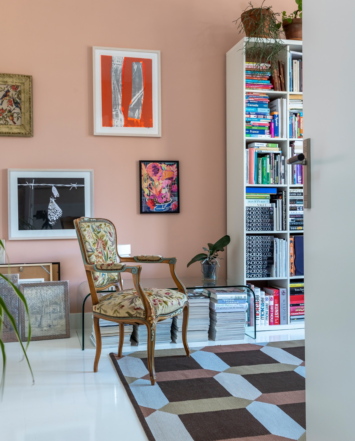 Muurverf Farrow &amp; Ball, kleurnaam onbekend. Kunst aan de muur v.l.n.r. Birgit Verwer, Marjan Laaper, Jochem Rotteveel, Johan Kleinjan, herkomst vintage stoel onbekend, glazen salontafel Murano. Kleed en boekenkast Ikea. Vloer witte epoxylak over oud parket.