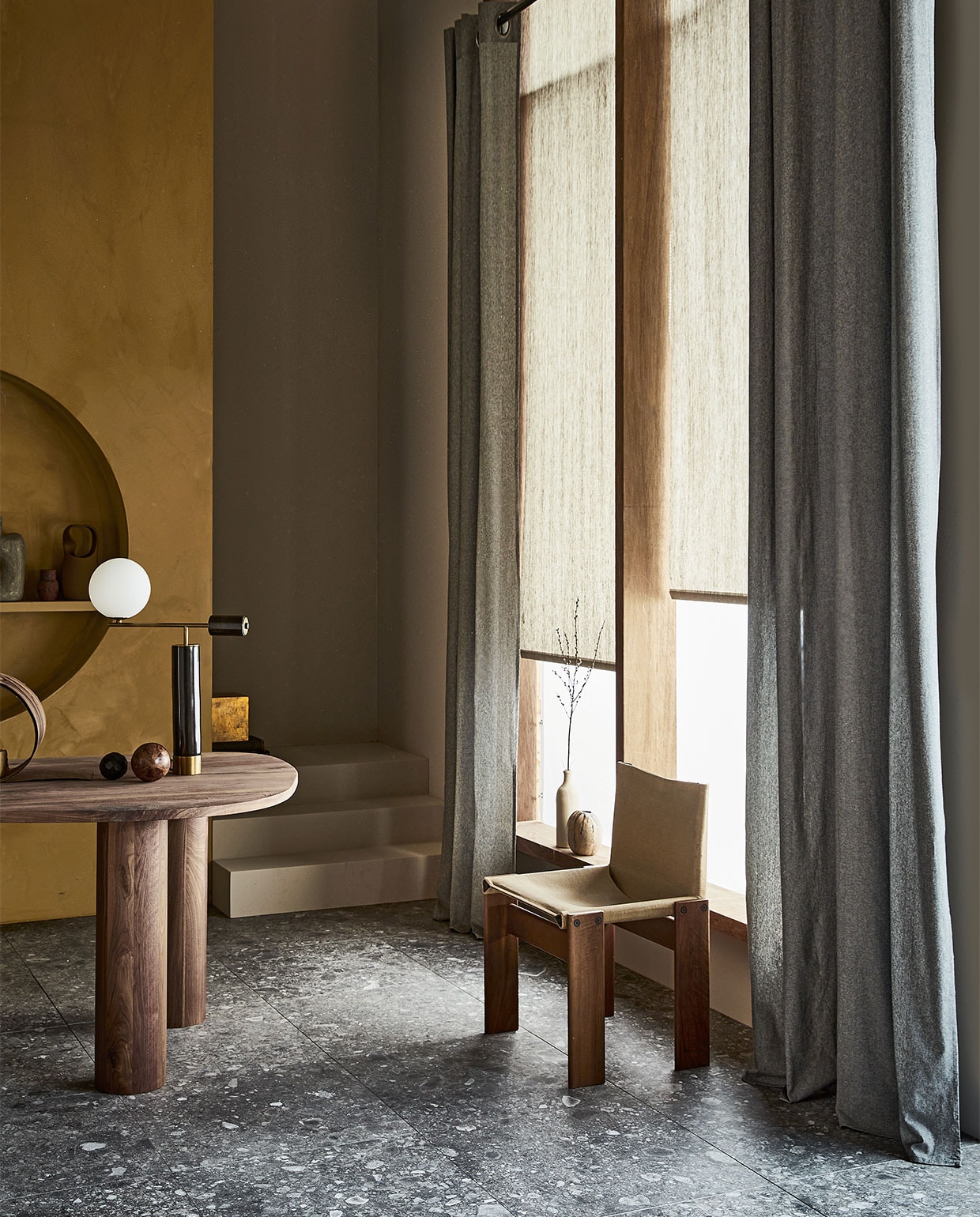 Gordijn Droplet, donkergrijs, lichtdoorlatend met ring, 270×140 cm (hxb) € 52,99. Rolgordijn Typhoon, lichtdoorlatend, 190×60/90/120/150/180/210 cm (hxb) vanaf € 45,29. M.m.v. karwei.nl (verf trap en achterwand Flax van vtwonen), vtwonen.nl (vloertegels Composite Multicolor van vtwonen), thomstudio.nl (walnotenhouten tafel), sitonvintage.com (stoel), neeflouis.nl (lamp), lauthentique.nl (muurverf lime paint oker 153), bloomingville.com (hoge vaas). Overig privébezit.