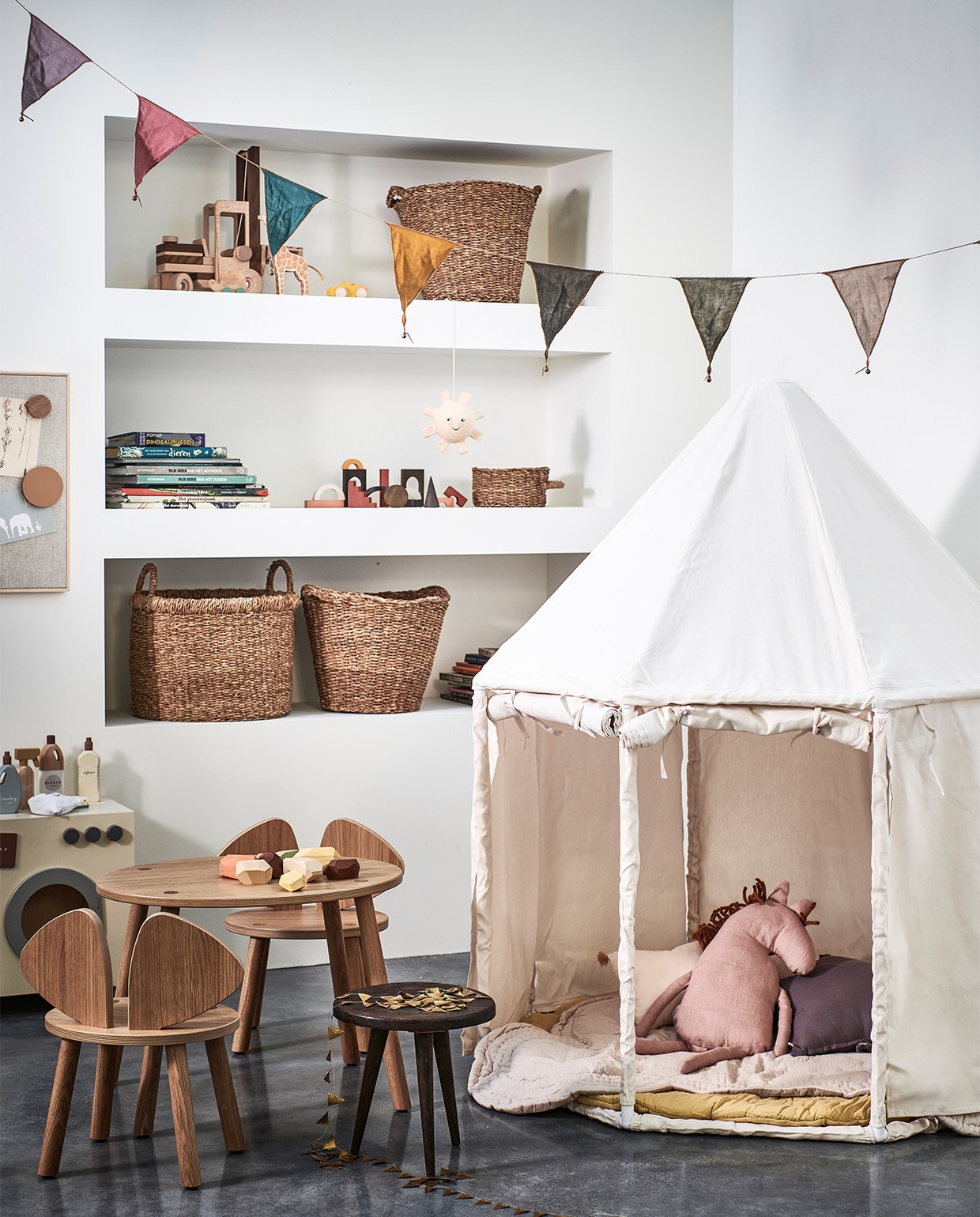 Canvas speelhuis van Kids Concept € 199,-, houten kindertafel Mouse van No Fred € 215,-, houten kinderstoel Mouse van No Fred € 185,-, magneet- en prikbord beige van Nofred € 135,-, magnetenset beige van Nofred € 40,- (vtwonen.nl). Houten wasmachine € 79,99, houten schoonmaakset € 29,99, muisvormige speelmat € 59,99, glow in the dark hanger zon € 17,99, opbergmanden met handvaten € 35,99, opbergmanden € 29,99, opbergmand met één handvat € 9,99 (zarahome.com). Knuffelkussen paard in Dusty Rose van Ferm Living € 55,- (storeofdaydreams.com). Stervormig kussen in kleur Dusty Lilac van Numero 74 € 19,-, roze kussen met kwastjes van Nobodinoz € 19,95, rond speelmatras Charlie in kleur Mellow Yellow van Numero 74 € 95,- (lidor.nl). Houten blokken Architectural Blocks van MinMin € 72,-, Balancing Stones pastel van MinMin € 46,- (gray-label.com). Houten vorkheftruck van Goki € 69,99 (lanoeka.com). Stoffen slinger multicolour van Numero 74 € 17,- (archive-store.nl). Overig privébezit.