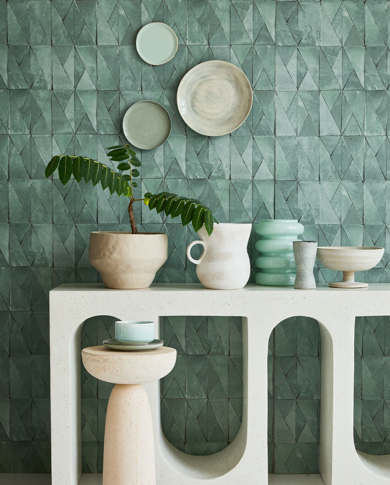 Behang Yazga in Pierre de Jade Ast nt 034 04, 100×70 cm per rol € 244,- (astere.fr). Microcement sidetable vanaf € 1850,- (lanena-home.com). Groot groen bord op de muur Wonki Ware, 30 cm (Ø) € 34,- (couleurlocale.eu). Klein mintgroen bord uit Goodmorning-collectie van Urban Nature Culture € 16,20 (vtwonen.nl). Groen bord linksonder € 6,50 (zarahome.com). Witte kan met oor € 59,95, schaal op voet € 59,95, mintgroene glazen vaas € 21,95 (urbannatureculture.nl). Mintgroene kom Munch € 45,- (groenenakker.nl). Bijzettafel € 650,- (edha-interieur.nl). Overig privébezit.