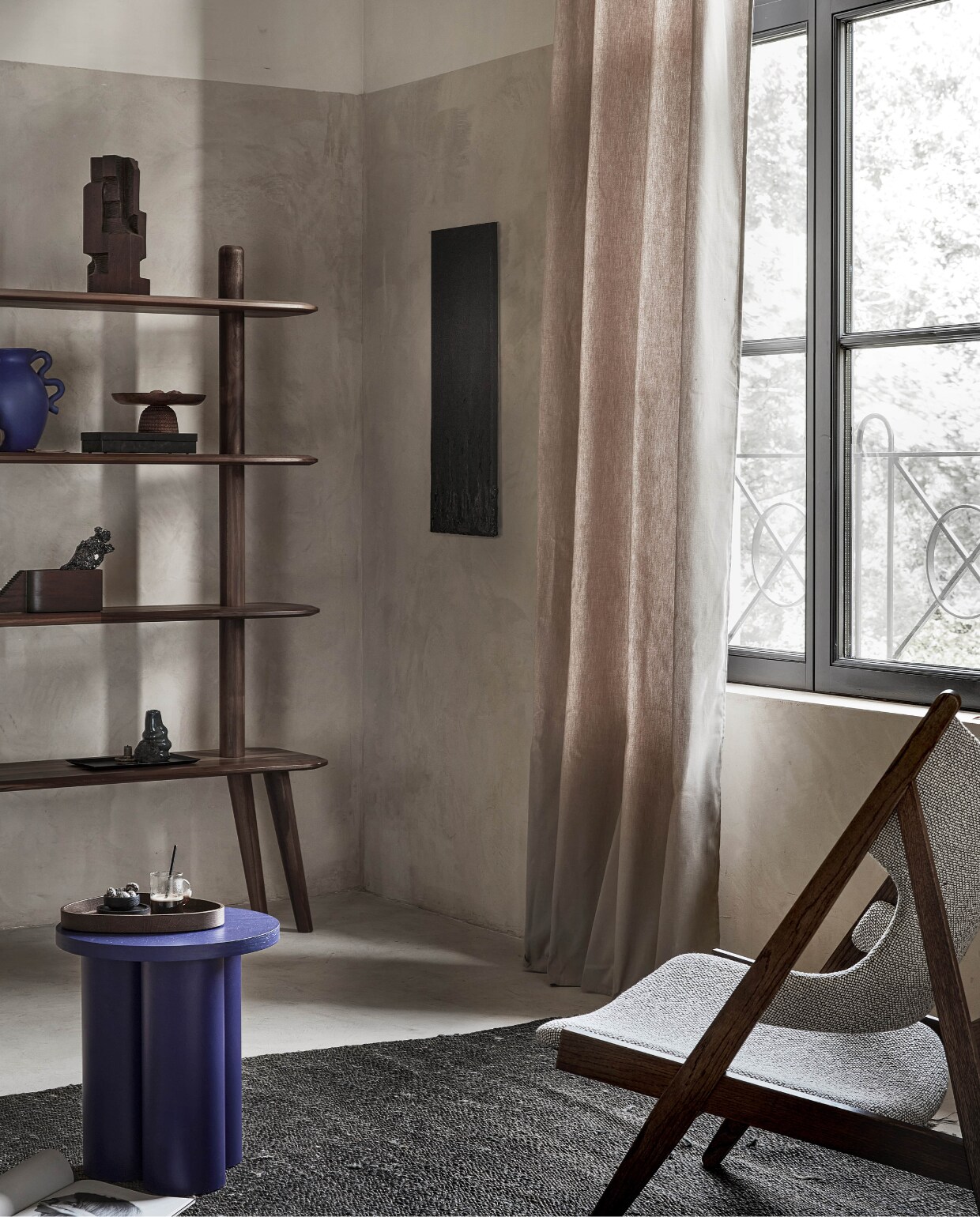 Taupe gordijn Denim Flax, lichtdoorlatend, met ring, 270×140 cm (hxb) € 55,99M.m.v. demachinekamer.nl (walnoothouten kast Olger van Sav &amp; Økse), designtales.nl (fauteuil van Menu), vtwonen.nl (bijzettafel Oly van noo.ma, blauwe vaas van Ferm Living), homestede.nl (houten sculptuur, notenhouten etagère, architectonisch sculptuur van hout, dienblad), hm.com/home (bruin aardewerken vaasje, bruine glazen vaas, blauwe glazen vaas), zarahome.com (zwarte stalen kistjes, zwart metalen dienblad, espressokop), 2222studio.com (plaid met print, zwarte mok met gezicht). Overig privébezit.