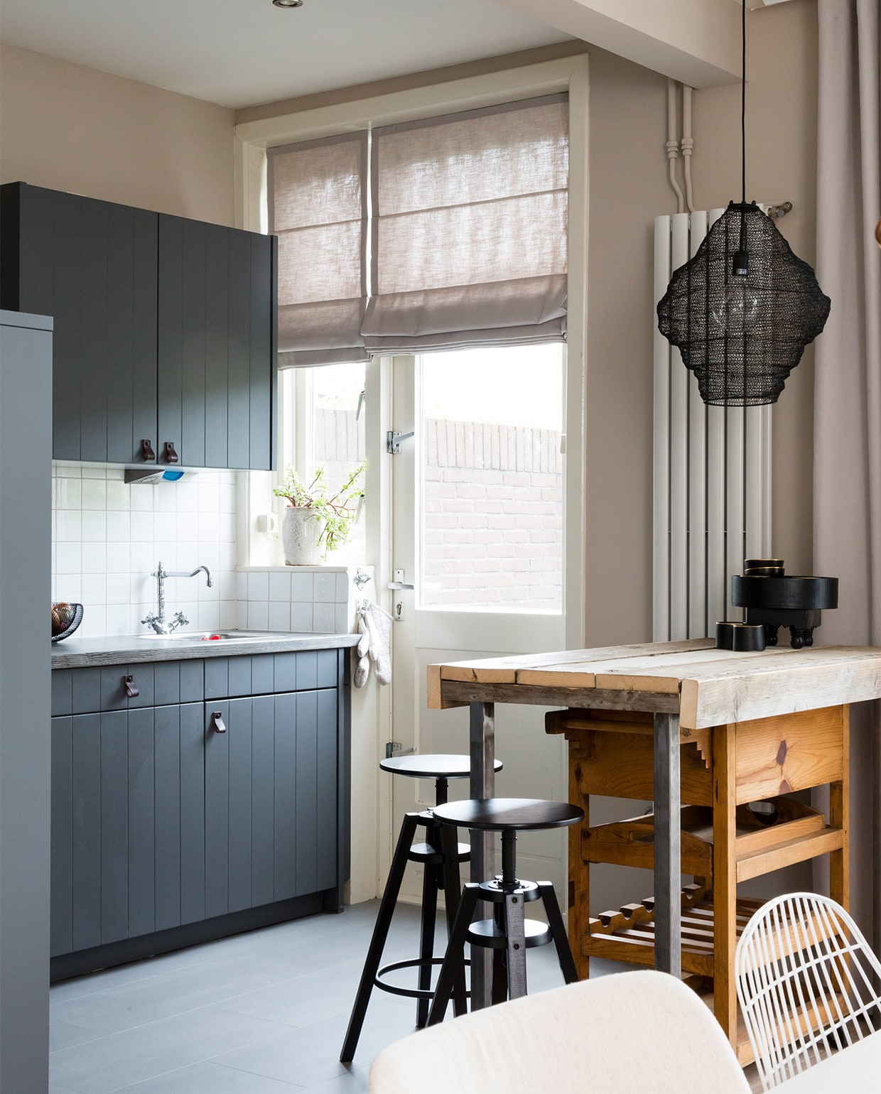 Op de vloer: PVC Black Jack Oak, prijs op aanvraag (Woninginrichting aan Huis). Krukken per stuk € 39,95 (Ikea). Hanglamp Vola € 69,- (By Boo). Leren greepjes op de keukenkastdeurtjes per 2 € 14,95 (Bodilson). Radiator onbekend