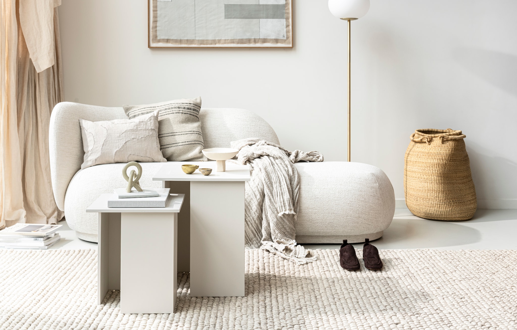 Bouclé driezitsbank Rico van Ferm Living € 2985,-. Wollen vloerkleed Peas van Hay, 200×300 cm € 999,-. Vloerlamp Alton van Nordlux, 150×27,5 cm (hxØ) € 143,95 (vtwonen.nl). Kunstwerken van July Adrichem (julyadrichem.com) in opdracht van Avenue Design Studio (avenue-designstudio.com). Suède loafers € 150,- (arket.com). Mand van olifantsgras van Twenty One Tonnes, 64 cm (h) € 275,- (pantoufle-design.nl). Witte schaal Rock Vessel van Marlies Huybs € 130,-. Spekstenen object Kisii S € 25,-, rechthoekig kussen van Marleen van Haaften in samenwerking met Studio Yen € 75,-, messing olielampjes van Casegoods, set € 30,- (studio-yen.com). Kussen Moroccan stripe € 105,- (billierose.be). Plaid 130×170 cm € 49,95 (hm.com). Overig privébezit. vtwonen 10-2021 |  productie &amp; styling kim van rossenberg | uitvoering Richard van Meerveld | fotografie Sjoerd Eickmans
