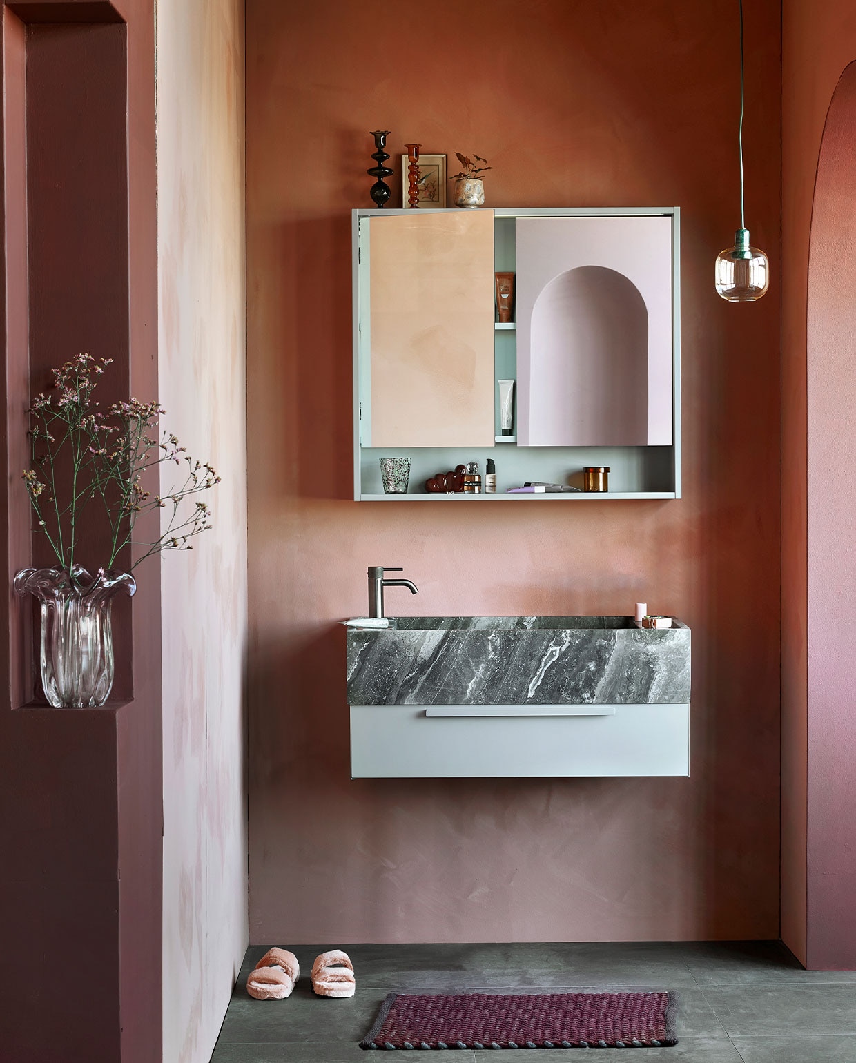 De . M.m.v. vestingh.nl (kleur op de muur Terra Pink No.102, kleur van kolom en rand toog Merlot Mania No. 123), zarahome.com (sloffen), vtwonen.nl (hanglamp Amp van Normann Copenhagen), hay.nl (bruine glazen opbergpot met deksel Container S, vloerkleed Burgundy, tandenborstel Tann, sculpture W&amp;S Moguls Burgundy), nordal.eu (gekleurde glazen kandelaars, roze vaas, gespikkeld drinkglas, roze marmeren bakje), stories.com (parfum, tubes, sieraden). Overig privébezit.