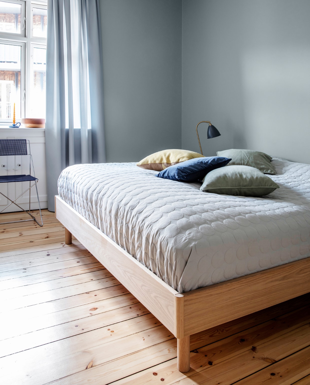 Muurverf Exhale van Jotun. Gordijnen Kvadrat. Bedsprei en kussens Hay. Tafellamp Gubi. Stoel uit lijn van Nie Kvadrat. Overig herkomst onbekend.