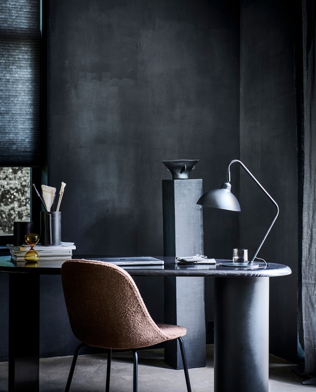 Matzwarte metalen tafellamp Orion, 50×36 cm (hxb), kap 22 cm (Ø), voetplaat 18 cm (Ø) . M.m.v. designtales.nl (bureau van Menu, stoel), letoile.store (zandloper, glas), hm.com (vaas). Overig privébezit.