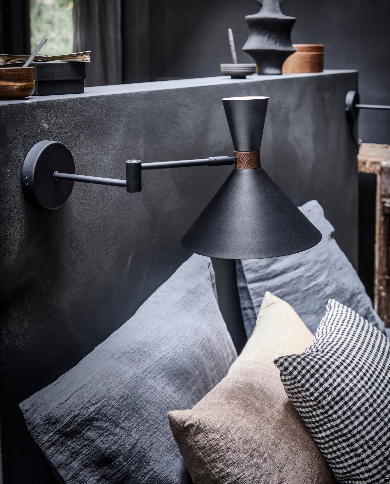 Matzwarte metalen wandlamp Hoodies, 25x25x50,5 cm (lxbxh) € 89,95 (ook verkrijgbaar in zandgrijs).M.m.v. bymolle.com (linnen kussensloop in kleur Slate), paviljoennoord.com (zwart-wit geruit kussen), letoile.store (beige linnen kussen).