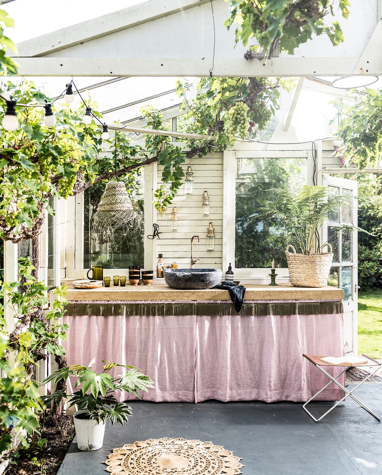 Franjeband in legergroen (aboeken.nl). Lichtroze linnen stof Brera Lino Pale Rose F1723/40 van Designers Guild (wva.nl). Aanrechtblad voorzien van beton ciré in de kleur Amarillo Miel (betoncirenederland.nl). Natuurstenen gootsteen met koperen kraan (oudebouwmaterialen.nl). Grote mand Essaouira Fishermen Basket, maat M, lampenkap Essaouira Triangle Closed, maat S, groene glazen Trad Mor, hoogte 12 cm, groene karaf, lantaarns, groene kandelaar uit de Tamegroute serie (householdhardware.nl). Kommen van keramiek met zwarte rand, grote borden (hkliving.nl). Handzeep Aesop (skins.nl). Fles zout, dressing Nicolas Vahé (societyoflifestyle.com). Grijze doek (hm.com). Overig privébezit.
