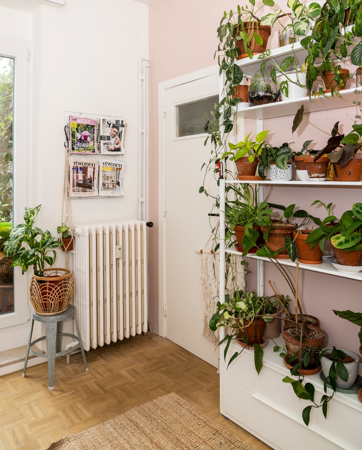 Muren geschilderd in Lovely White WE Z042 en roze (nummer onbekend) van Boss Paints via Colora. Groot wit rek, tapijt Ikea, tijdschriftenrek Hema. Metalen kruk Sissy-Boy, bloempot H&amp;M Home.