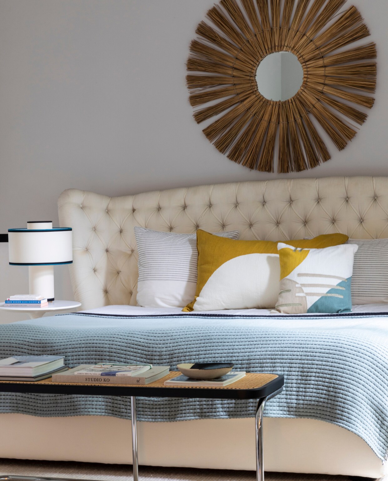 Bed Promemoria. Bijzettafels Knoll. Lampen, sprei en gestreept vloerkleed Maison Sarah Lavoine. Bankje The Socialite Family. Spiegel Honoré Décoration. Geel kussen Élitis, kussens met print uit Los Angeles.