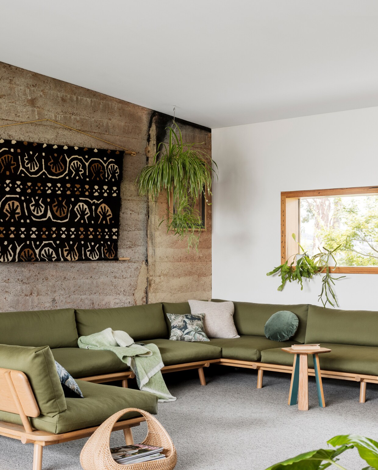 Vloerbedekking Cavalier Bremworth. Bijzettafel en bank Nicholls Design, olijfgroene bekleding Sustainable Living Fabrics. Plaid St Albans. Kussens Louise Jones Interiors. Afrikaans wandkunstwerk gekregen. Mand Freedom.