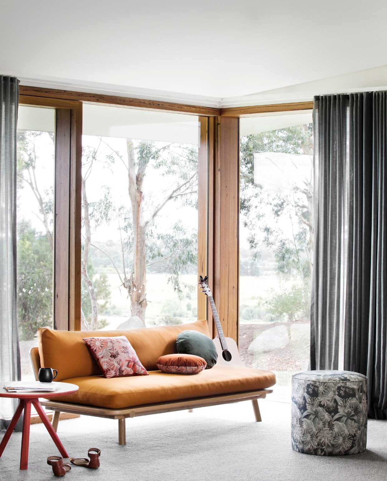Bijzettafel en bank Nicholls Design, oranje bekleding Sustainable Living Fabrics. Poef Louise Jones Interiors