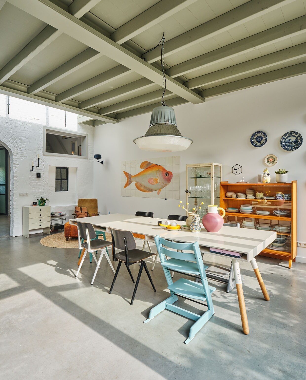 Verfkleur plafond Sikkens H2.05.65. Eettafel Phill Spectrum. Stoelen S16 Galvanitas. Kinderstoelen Tripp Trapp Stokke. Blauwe kruk Tolix. Peper-en-zoutstel Lego. Gele kandelaar Arian Brekveld voor Imperfect Design. Roze bolvaas Ypperlig Ikea. Wandkandelaar Frederik Roijé. Wandlamp Bolt Tonone. Wanddecoratie Yellow Fish IXXI. Vloerkleed Kwantum. Kasten, lectuurtafel, Martin Visser-fauteuil, voetenbank, hanglamp en verzameling wandborden vintage.