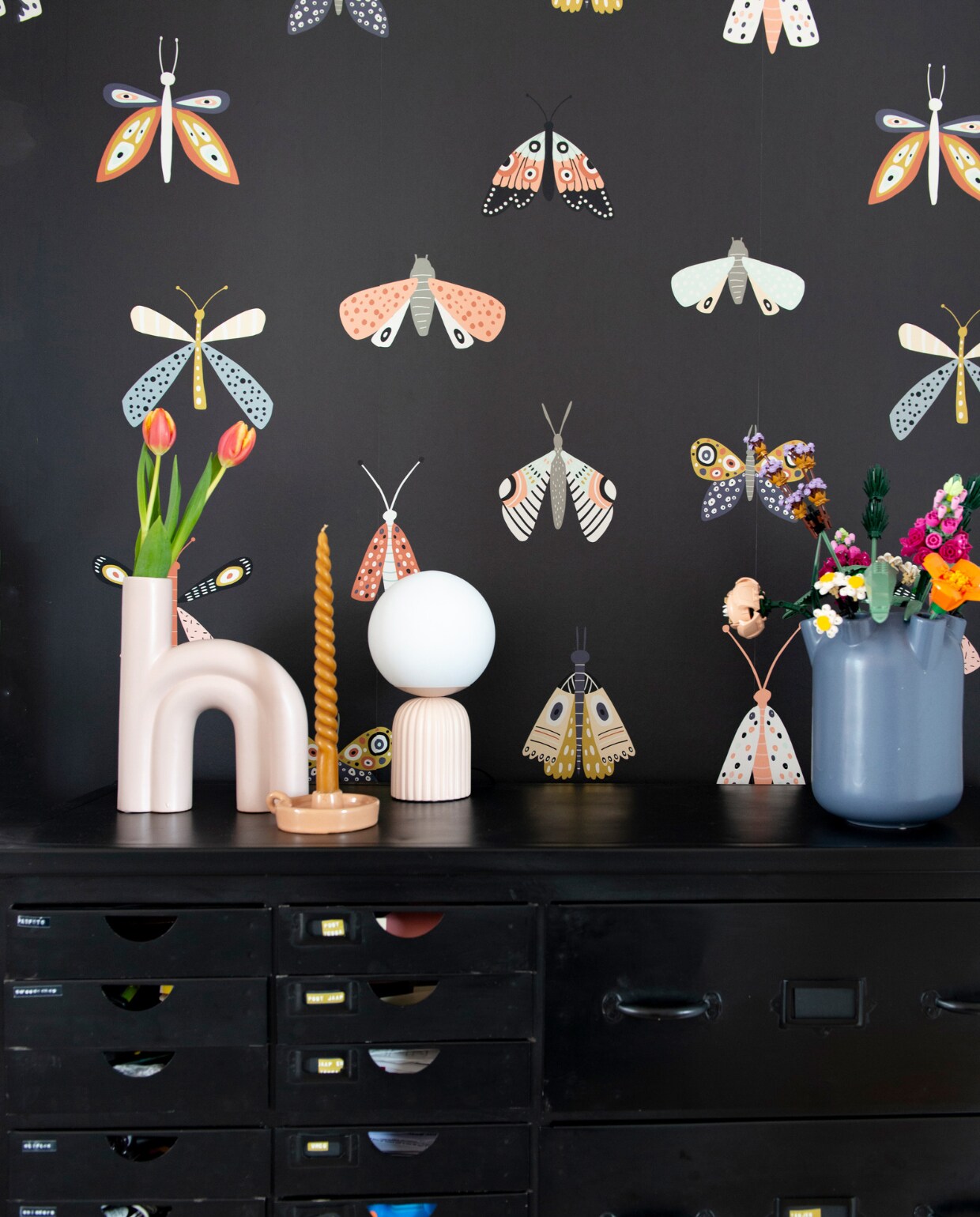 Behang vlinder Binnenzoet. Kast Gigameubel. Boogvaas Intratuin, tulpenvaas Hema, bollamp Kwantum, kaars Dille &amp; Kamille, bloemen Lego. Overig onbekend.
