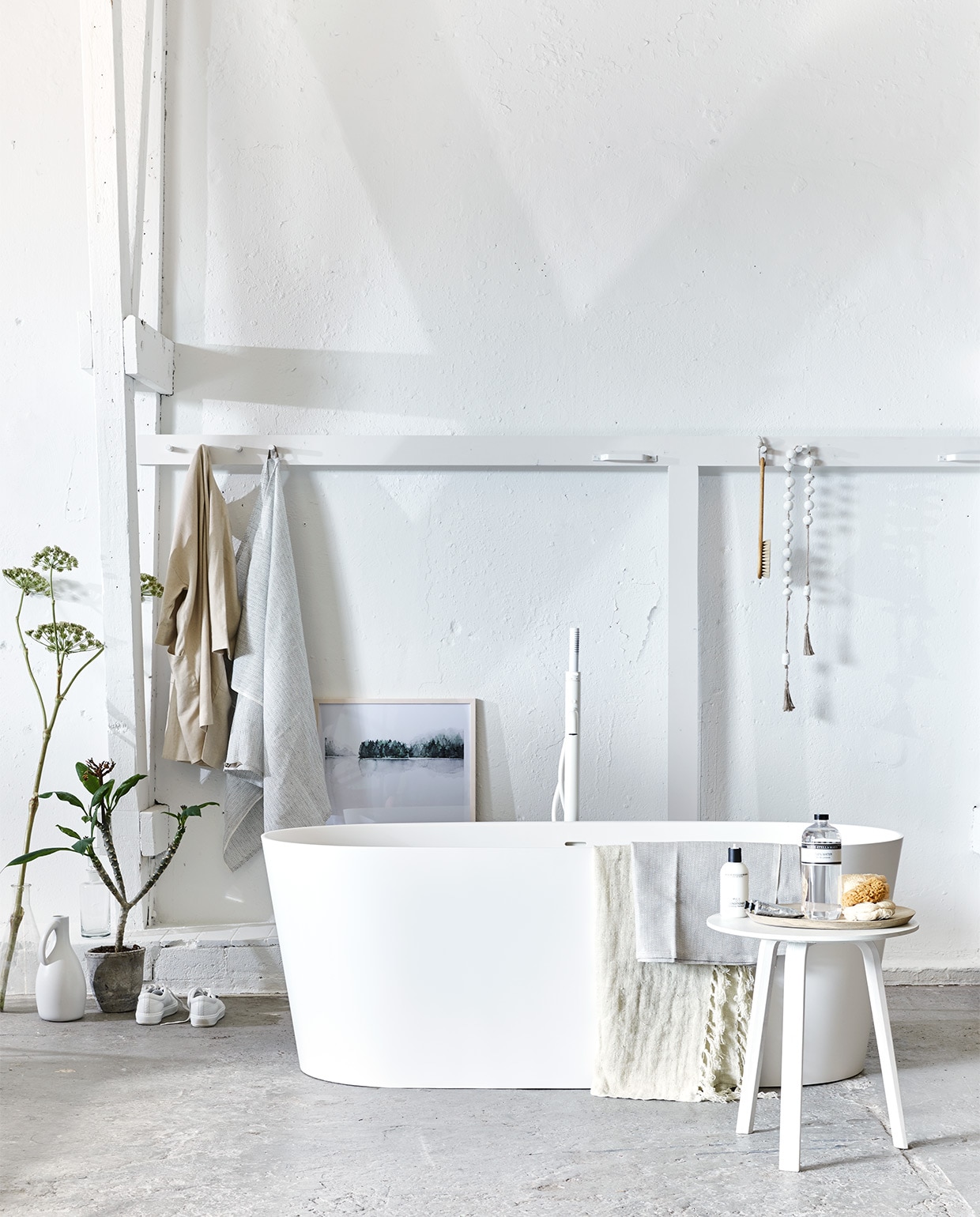 Vrijstaand bad Tub van vtwonen 165x72x60 cm, vrijstaande badmengkraan Curve (www.vtwonen.nl/vtwonen-collectie). Tafel Bella (Hay Amsterdam). Afbeelding Calm Botanics in lijst, 50×70 cm exclusief lijst, grote fles geurwater van Marie-Stella-Maris, kleine fles, badborstel, linnen badlakens No.6 (My Deer’s). Kralenketting (Couleur Locale). Linnen jas (Six and Sons). Linnen doek met franjes (De Weldaad). Labfles (Neef Louis). Kapstok met haken vanaf (Combitex). Houten schaal (HK Living). Natuurspons (&amp;Klevering). Gympen (Acne Studios). Overig privébezit.