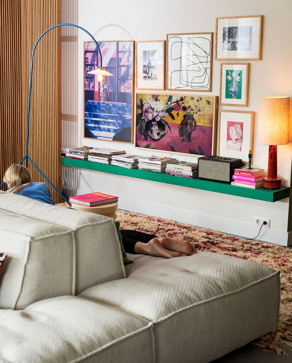 Houten hoeklatten op maat gemaakt door meubelmaker Peter Vocking. Blauwe staande lamp Valerie Objects. Televisie Samsung the Frame Wood. Muziekbox Marshall. Kleed vintage berber via Etsy. Kunst eigen verzameling. Elementenbank Square van Easy Sofa.