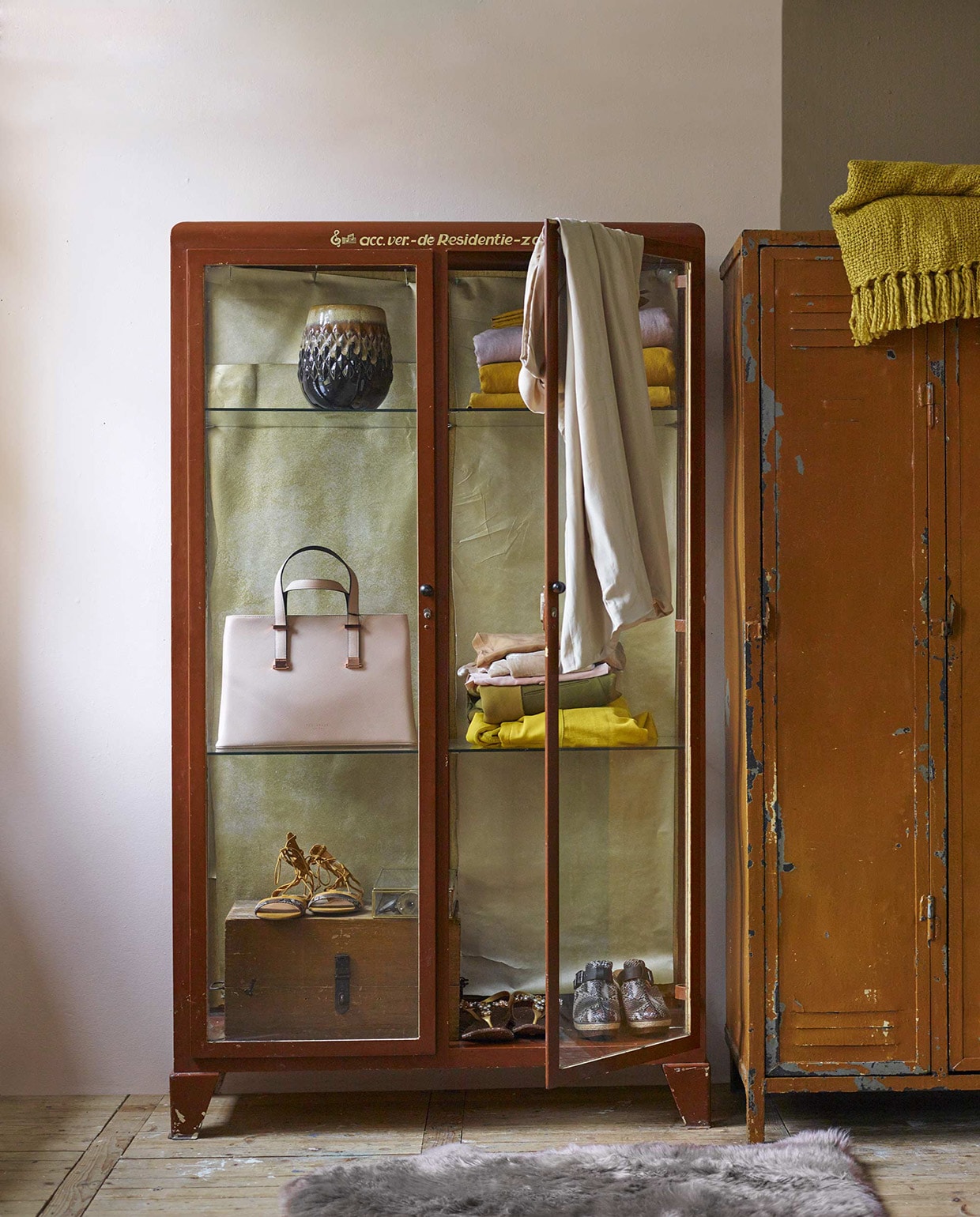 Muurverf Honeymoon per liter € 20,50 (Dimago). Muurverf kalkmat Real Greige uit de Pure collectie € 25,95 (Flexa). Glazen apothekerskast € 895,-, lockerkast € 300,-, houten kist € 75,- (Neef Louis). Vaas € 25,- (Nijhof). Schapenvacht € 39,95 (Ikea). Glazen opbergkistje van Madam Stoltz per stuk vanaf € 6,25 (www.deens.nl). Okergeel plaid € 39,95 (Malagoon). Kussenhoezen in okergeel en poederroze per set van één kleur € 22,95 (Sissy-Boy). Jurk (Gestuz). Tas (Ted Baker). Overig privebezit.