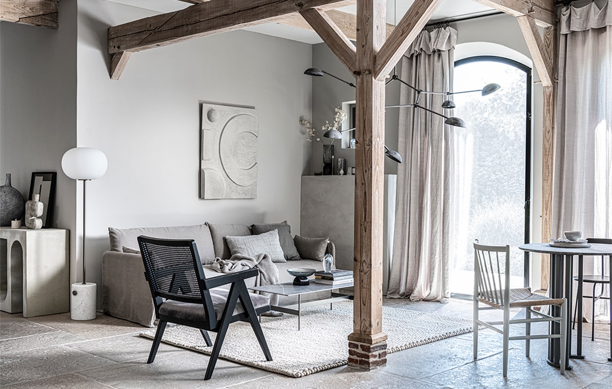 Op de wand kalkverf Old Flax van Pure &amp; Original, 1 liter € 40,75 (pure-original.nl). Vloerkleed Tararu, 220×300 cm € 9940,-(kristiinalassus.com). Kunstwerk N°05 in kleur Stone, 60×40 cm prijs op aanvraag (atelierledition.com). Percolator Lady Anne € 59,-, tweekleurige keramieken mok Earth € 17,50 (bymolle.com).Bruine mok € 5,90 (letoile.store). Vloerlamp Line One met onbehandelde mat marmeren voet en geoxideerde aluminium kap € 650,- (norr11.com). Bank op maat gemaakt, prijs op aanvraag, kandelaars, 30, 40 en 50 cm (h), set van 3 € 46,-, bijzettafel antiek brons, 36×49 cm (Øxh) € 85,- (stylexclusief.nl). Rechthoekig kussen, 30×50 cm € 7,99, vierkant kussen, 50×50 cm € 35,99 (zarahome.com). Kussen Twine, 40×60 cm € 179,-, fiberglass kuipstoel Eames DAX van Vitra € 750,- (homestede.nl). Grijsblauw gestreept kussen van by Nord € 59,95, gebreide plaid Pien, 130×170 cm € 69,95 (loftloft.nl).