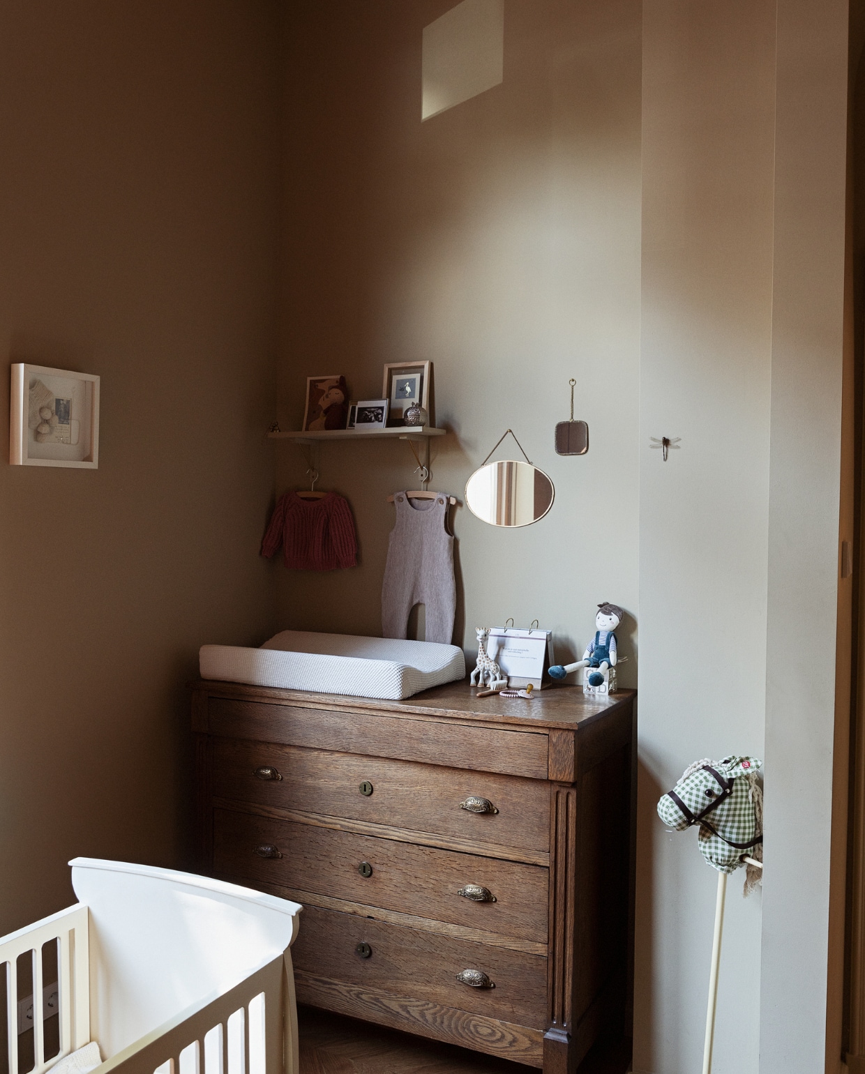 Ledikant van Louks familie. Commode Marktplaats. Aankleedkussenhoes gemaakt door Lidians moeder. Stokpaard kraamcadeau. Spiegels De Weldaad. Wandplank Søstrene Grene. Kunstwerk ooievaar Sjakie’s. Kunstwerk Mia @andwonderstudio. Overig onbekend. vtwonen BK8- 5 2022 | styling Ilona Jongepier |  fotografie Dana van Leeuwen