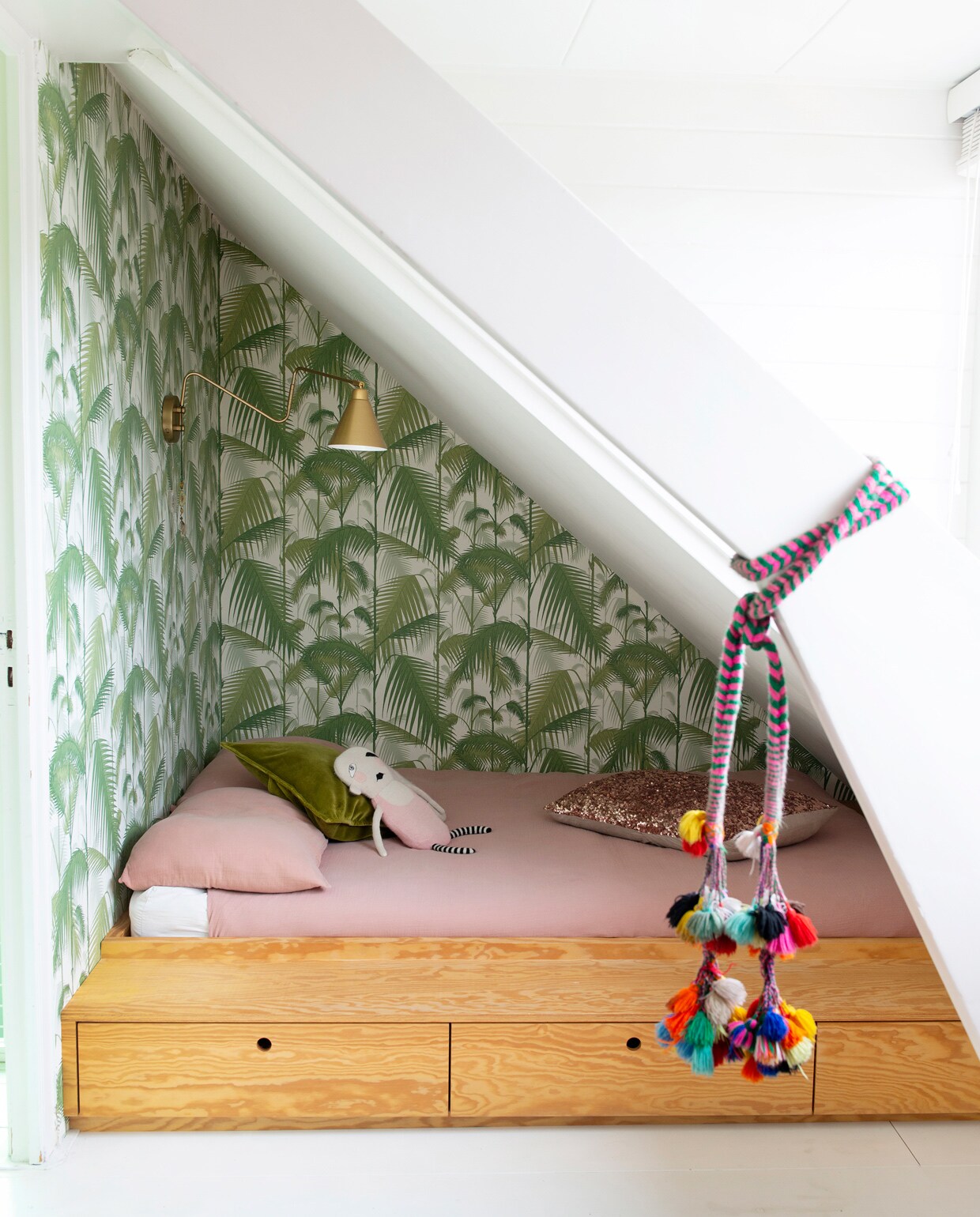 Op de kamer van Maggie een wandrek met bureau van String. Print van Parijs door Famille Summerbelle, Batgirl-print van Mini &amp; Maximus, stoel van een rommelmarkt. Links in het rek modernistisch poppenhuis Villa Sibis van Sirch. Poppetjes van Petit Depot, karpet uit Marokko, lamp House Doctor, kledingkast vintage. Herkomst overig onbekend.