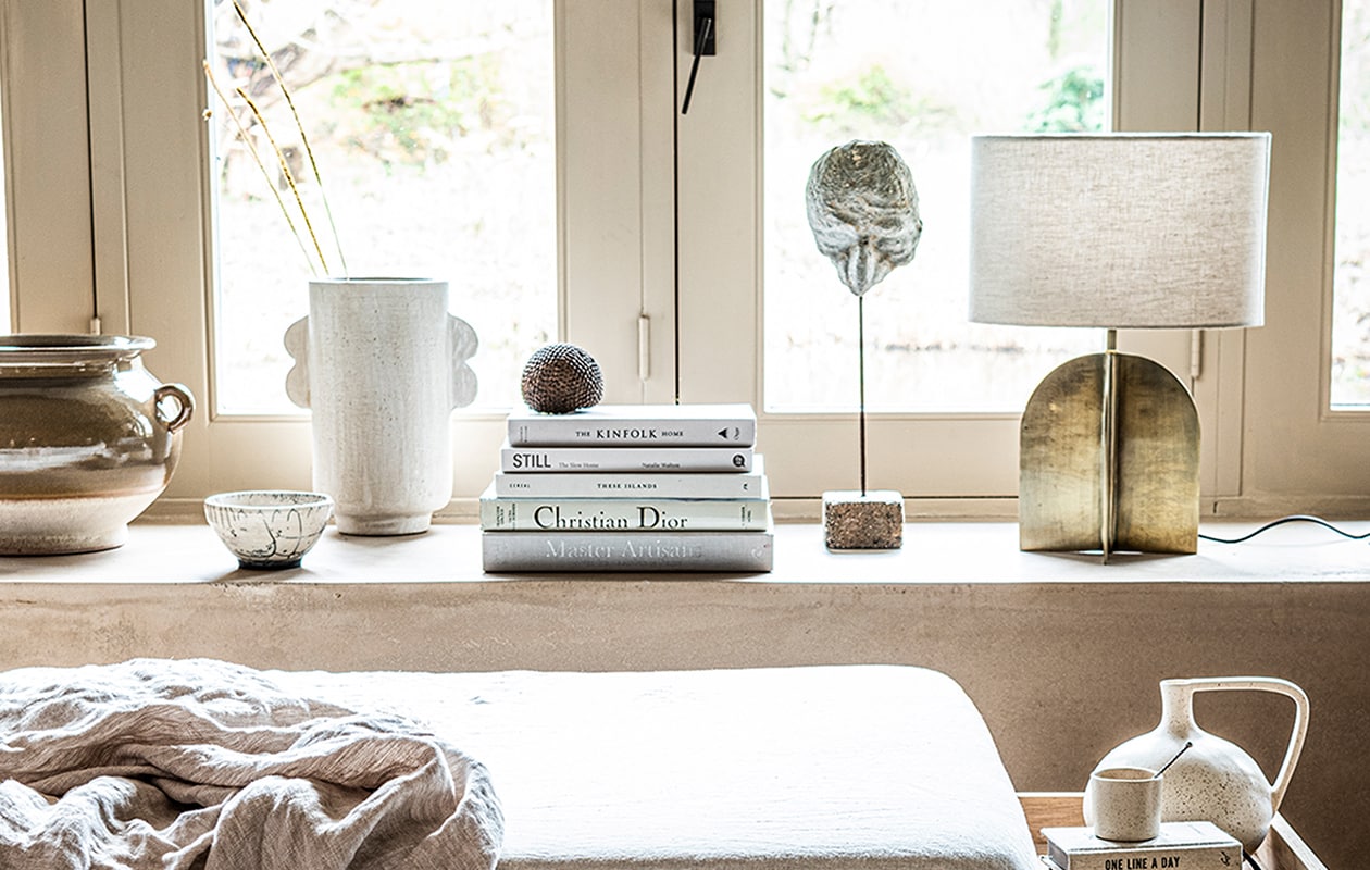 , Witte, gespikkelde vaas van HKliving € 34,95 (vtwonen.be). Vloerkleed 200×300 cm € 169,-, linnen deken 140×190 cm € 79,99, lamp met goudkleurige metalen voet € 89,99, verwassen linnen onderlaken € 45,99, bruine pot met oortjes € 59,99 (zarahome.com). Beige aardewerken vaas met darius oortjes van Urban Nature Culture € 49,99 (sissy-boy.com). Overig privébezit.