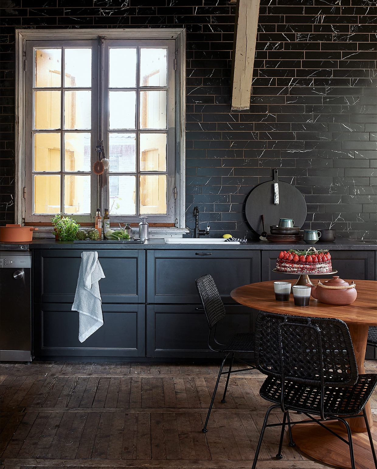 Classic Black mat 7,3×30 cm per m² € 81,50, ook verkrijgbaar in Antracite, Grey en White in de maten 74×148 cm, 74×74 cm en 30×60 cm.M.m.v. hkliving.nl (servies, houten plank, borstels, stoelen), demachinekamer.nl (ronde tafel), loods5.nl (theepot, zoutstrooier, oliekannetje, theedoek), overig privébezit.