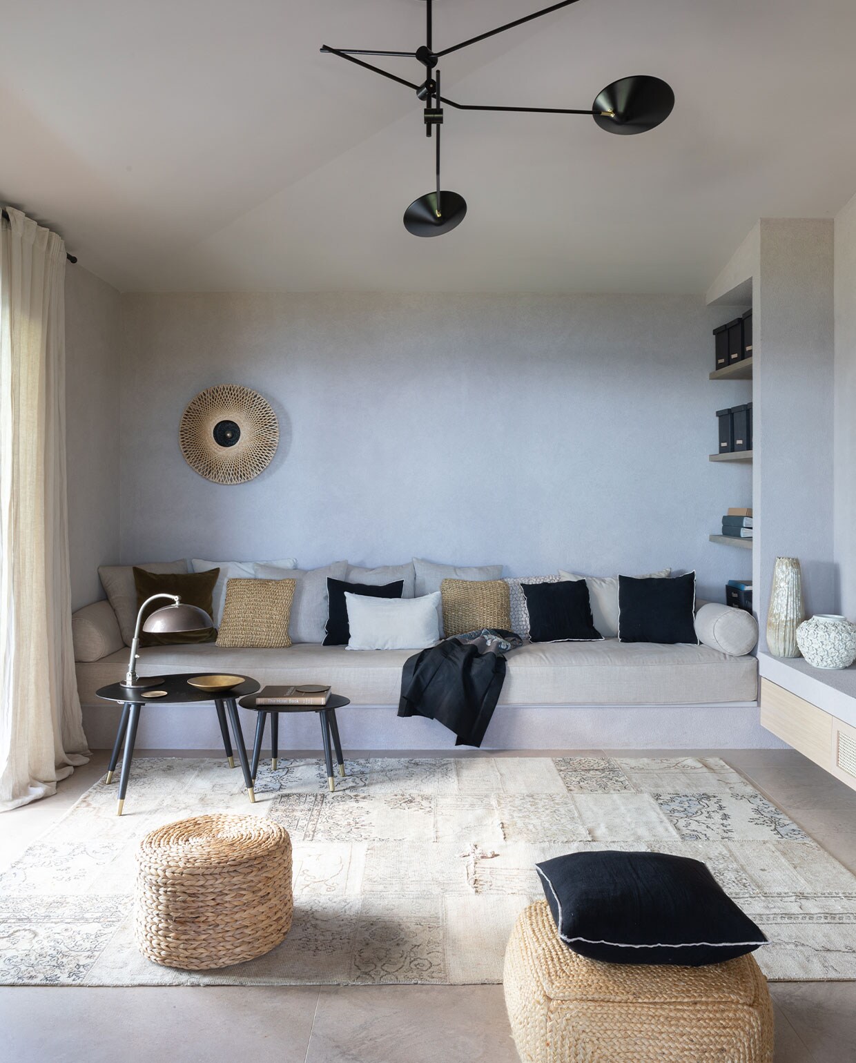 De televisiekamer. Betonnen, gestuukte bank, open kast en zwevende ladekast ontworpen door Hanne Poli. Matraskussen Dettagli Arredamenti. Plafondlamp Neron Westwing. Wandlamp Kalimantan van It’s about Romi. Leeslamp Hala vintage. Antiek vloerkleed Tisca. Overig onbekend.