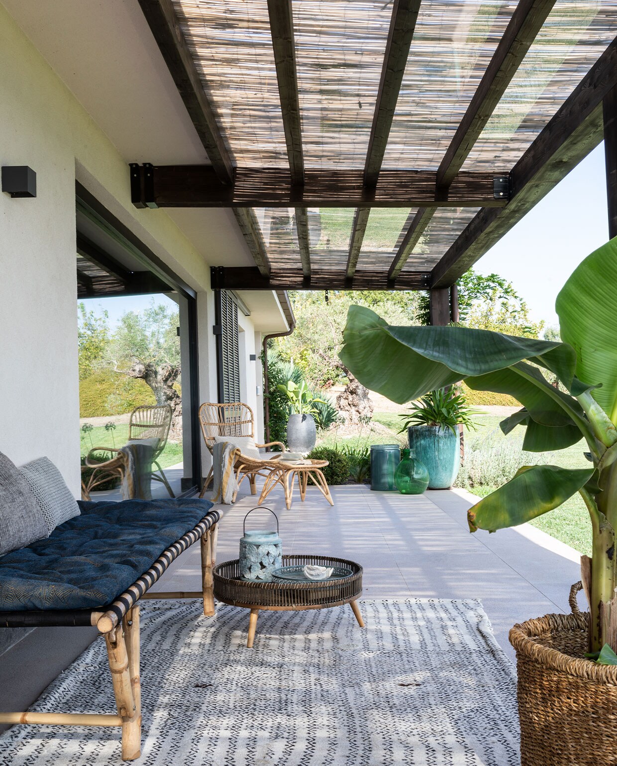 Daybed van Dettagli Arredamenti. Matras op maat gemaakt. Rotan loungestoel Ella van Venture Design. Antiek vloerkleed Tisca. Bamboe lantaarn Pomax. Overig onbekend.