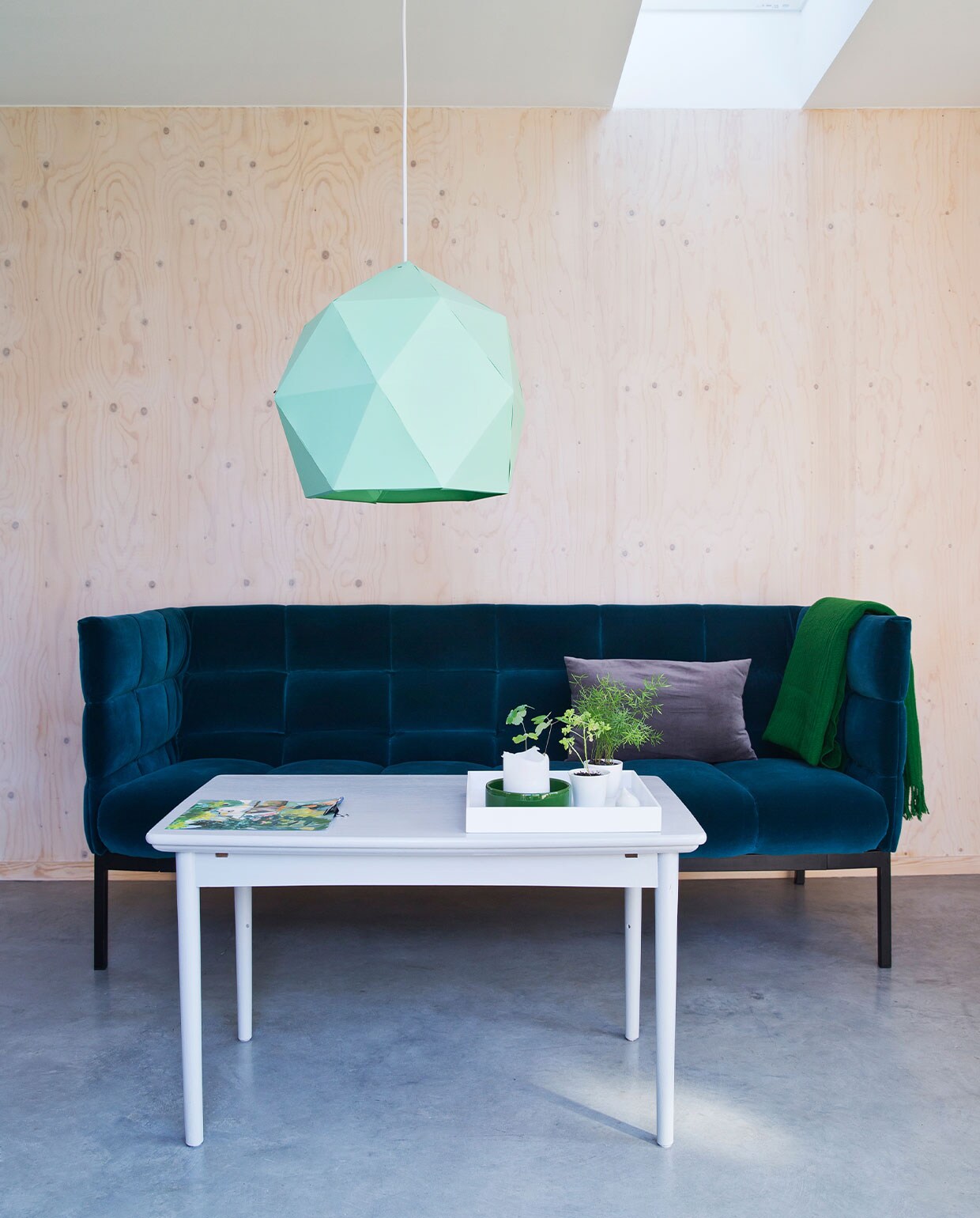 Bank Aura van Bolia. Kussen, plaid, hanglamp Ikea. Salontafel en woonaccessoires op tafel kringloop.