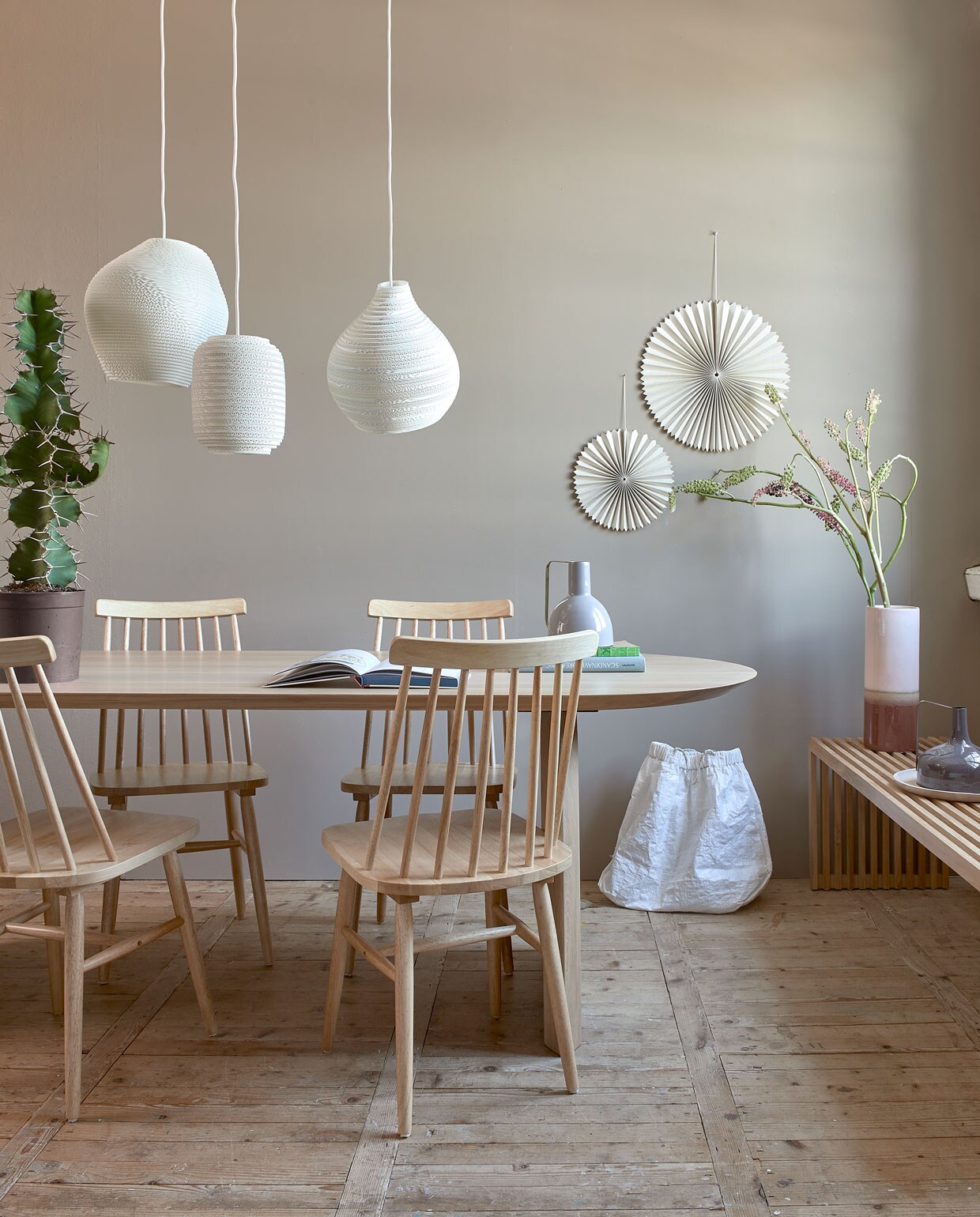 Muurverf Mire van vtwonen, per liter € 20,99, per 2,5 liter € 35,49. M.m.v. eijerkamp.nl (tafel Slot van Studio Henk), vtwonen.be (spijlenstoelen, hoge vaas, vaas met handvat, houten bord), vanmokum.com (lampen Graypants), sukha.nl (waaiers, witte tas). Overig privébezit.