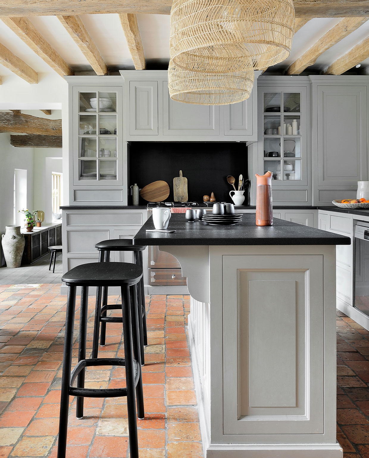 Keuken op maat gemaakt met granieten blad en geverfd in Manor House Gray van Farrow &amp; Ball. Lampen Ball HKliving. Krukken Paddle Cruso. Zwart servies 101 Copenhagen. Karaf Junto Normann Copenhagen. Kruik van Belgische rommelmarkt. Tafellamp Frandsen. Overig onbekend.