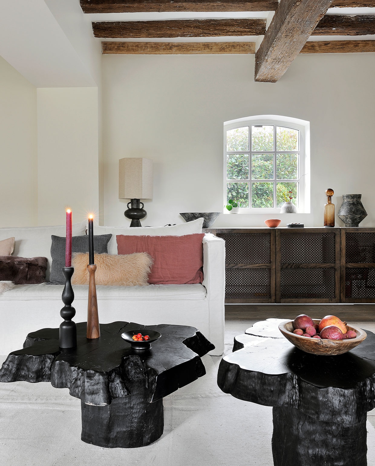 Bank Tine K Home. Bijzetafels Opiki van AM.PM. Kandelaren Kinta Atelier Germain. Houten schaal Rochel Habitat. Karaf van gerookt glas Fleux. Grote vaas Greek Terracotta 101 Copenhagen. Tafellamp en vloerkleed HKliving. Wandkast op maat gemaakt. Overig onbekend.