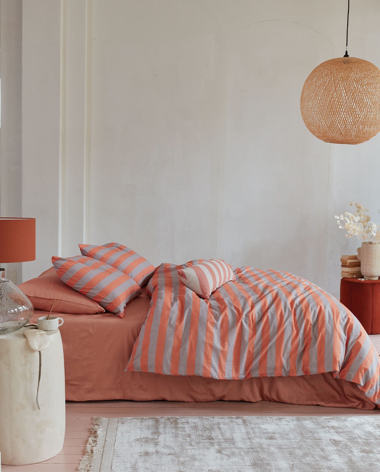 Katoenen dekbedovertrek Bold Stripe, 100% katoen, kleur Peach, 140×200/220 cm € 59,95, 200x 200/220 cm € 109,95, 240×200/220 cm € 119,95, 260×200/220 cm € 139,95. Kussen Bold Long, acryl en polyester, kleur Peach, 30×90 cm € 39,95.M.m.v. mimiettoi.com (keramieken bijzettafel), sissy-boy.com (tafellamp, fluwelen poef, vaas), letoile.store (mok, hanglamp), nordal.eu (slaapmasker, vloerkleed). Overig privébezit.