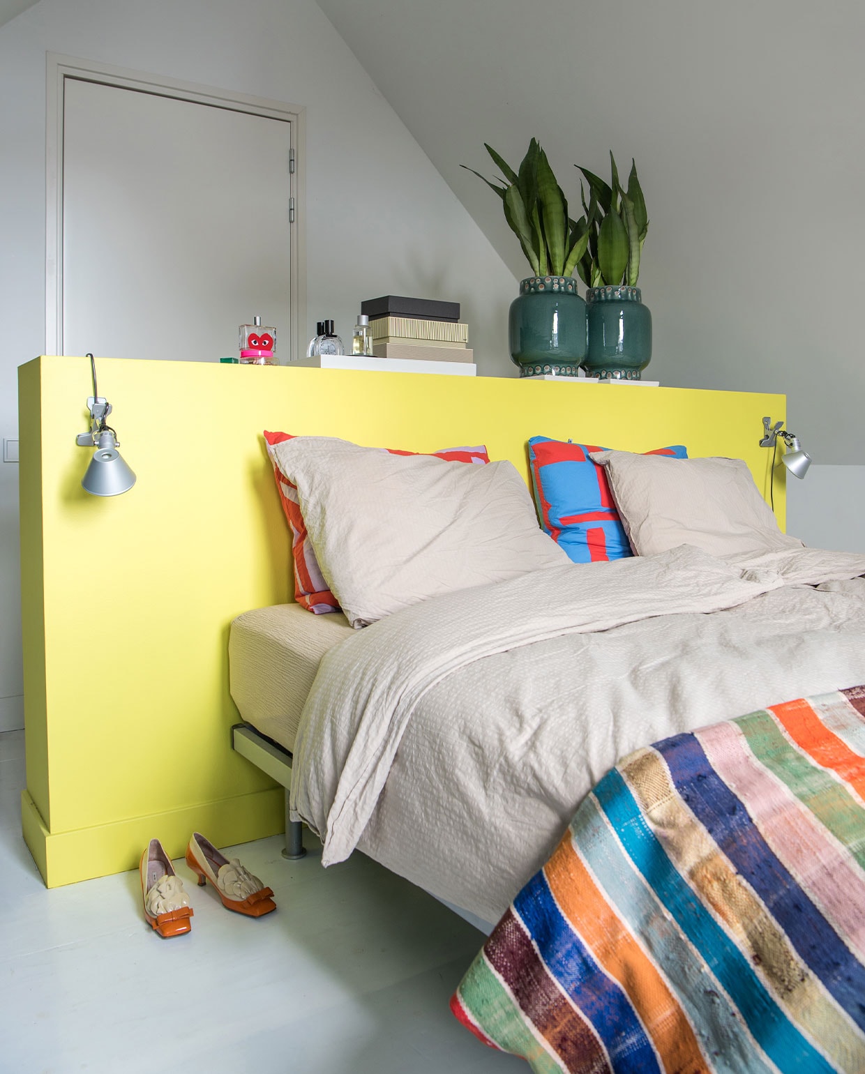 Dekbedovertrekset Crisp Sheets, gekleurde kussens Jantien Baas, plaid Le Petit Nomade, lampen Artemide, opbergdozen Hay, potten Nijhof, schoenen Miu Miu. Verf ombouw RAL 1016.