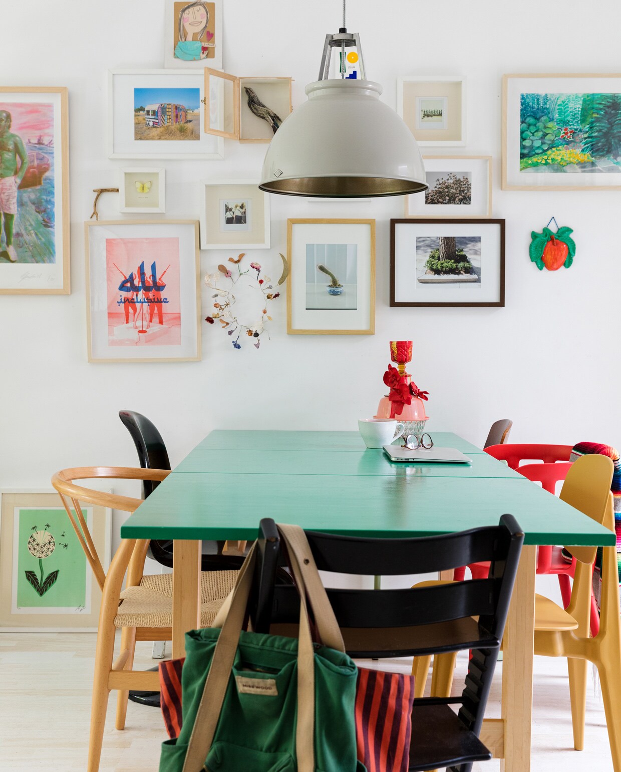 Tafel Ikea. Muurverf Tijdloos Hoogglans Gamma. Lamp Original BTC. Stoelen: rood Ikea, geel Loods 5, zwart de Tripp Trapp stoel van Stokke en een kopie van de Panton Chair van Vitra, hout een kopie van Carl Hansens Wishbone Chair. Mexicaanse plaid Tica. Groene rugtas Miss Wood. Rood gestreepte tas Sissy-Boy. Vaas Vazen van Janssen. Mok Xenos. Lijsten: Vogel van Elke Lutgerink. Zeefdruk man met roze broek Gies Backes. Appel-hanger en geschilderde tuin van de kringloop. Foto’s Maarten Kuypers. Gehaakte caravan gekocht in een gallery in New York. Plantaardige kroon Loesje van Herp. Riso print All Inclusive Julian Hetzel. Meisje van karton Anna Llenas. Paardenbloem zeefdruk herkomst onbekend. Foto bloesem Lineke Theelen. Gele vlinder gekregen van een vriendin.