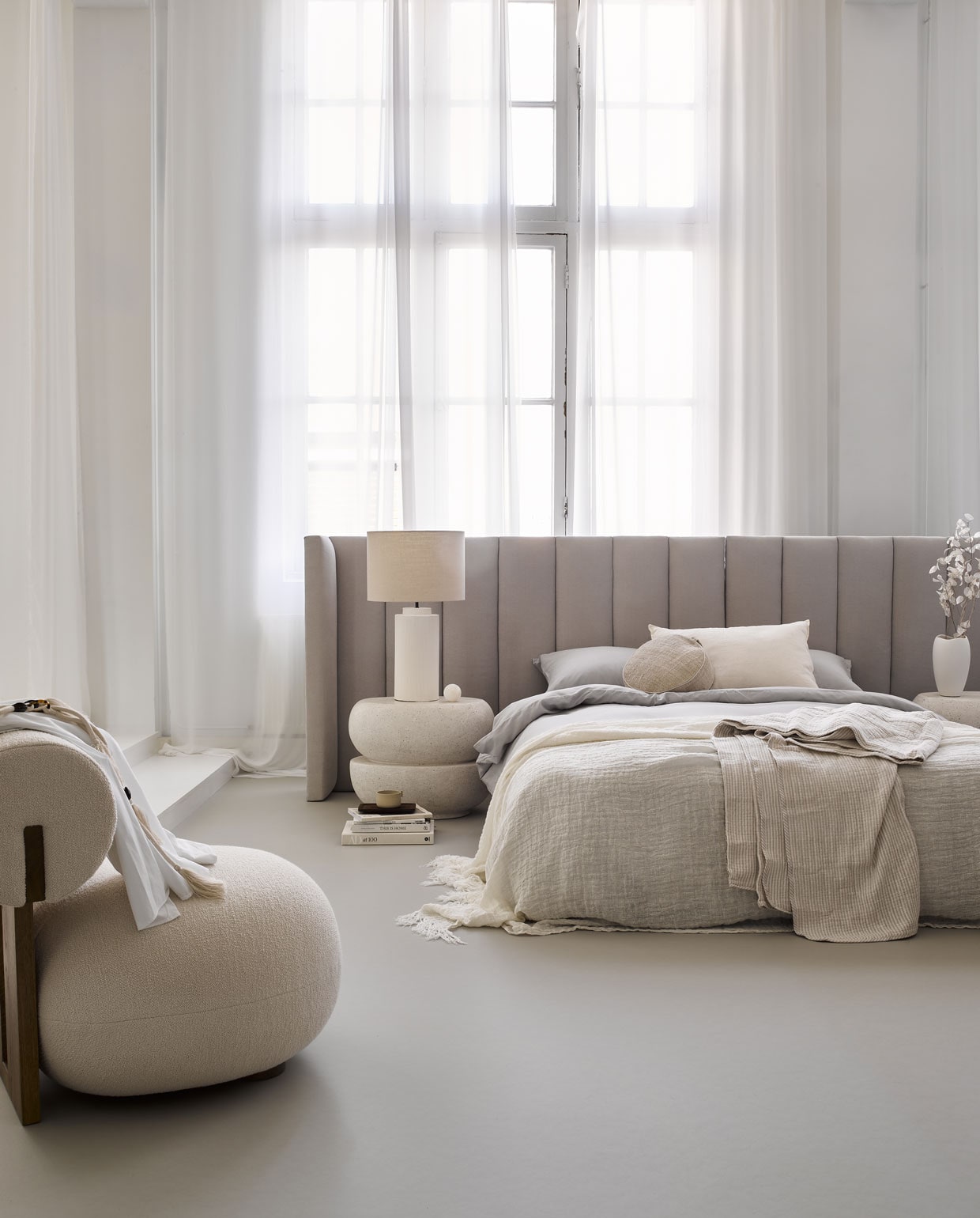 Marmoleum vloer kleur Zilver vtwonen 07, per m² € 48 (excl. installatie)M.m.v. Stoffeershop.nl (Headboard is op maat gemaakt) Bondinterior.nl (fauteuil van Nor11 ) Lanena-home.com (bijzettafel van microcement), hm.com (beddengoed, gestreept sprei), Zarahome.com (lamp en vaas), Nordal.eu (wit linnen kussen en linnen sprei)