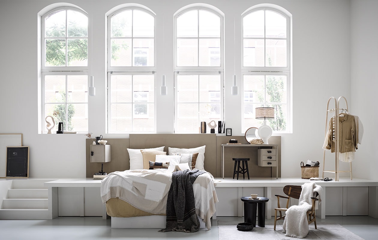Bureau kringloop € 20,- (kringloopwinkelleiderdorp.nl). Ingelijste print op grond groot € 399,- en klein € 299,-, beige-wit plaid € 659,- kaars op vensterbank, set van 3 € 45,- (sukha.nl). Beige ornament op vensterbank € 86,- (vtwonen.be). Zwarte vaas met handvat € 89,- en gestreepte vaas op vensterbank € 89,-, vloerkleed € 1695,- (couleurlocale.eu). Marmeren schaal op vensterbank € 45,99, beige kussen set van 2 € 45,99, wit kussen € 45,99, dekbedovertrek 200×220 cm € 79,99, zwarte kandelaar naast bed € 15,99, ronde spiegel € 69,99, katoenen toilettas € 19,99, instappers € 25,99, zwarte slippers € 19,99, linnen bloes € 45,99 en witte bloes € 45,99 (zarahome.com). Witte lampenvoet € 2154,-, zwarte kruk met twee poten en zwarte schaal prijs op aanvraag (covanderhorst.nl). Siervorm rechts op vensterbank € 24,99, zwarte kruk € 59,99, webbing lampenkap € 39,99 en mand € 39,99 (hm.com). Minivaas € 15,- en zwarte kan op nachtkastje € 55,- (fermliving.com). Papieren ornament in zwamvorm op nachtkastje prijs op aanvraag (elsavisser.com). Gestreept kussen € 110,-, grijs plaid € 255,-, beige mokje € 9,90, kledingrek € 569,- met slinger eraan € 32,90 (letoile.store). Kussen met motief op bed gemaakt van stof Escale Élitis per meter € 225,- (loggerewilpower.com). Houten fauteuil € 2804,- (homestede.nl). Wit plaid € 199,- (bymolle.com).
