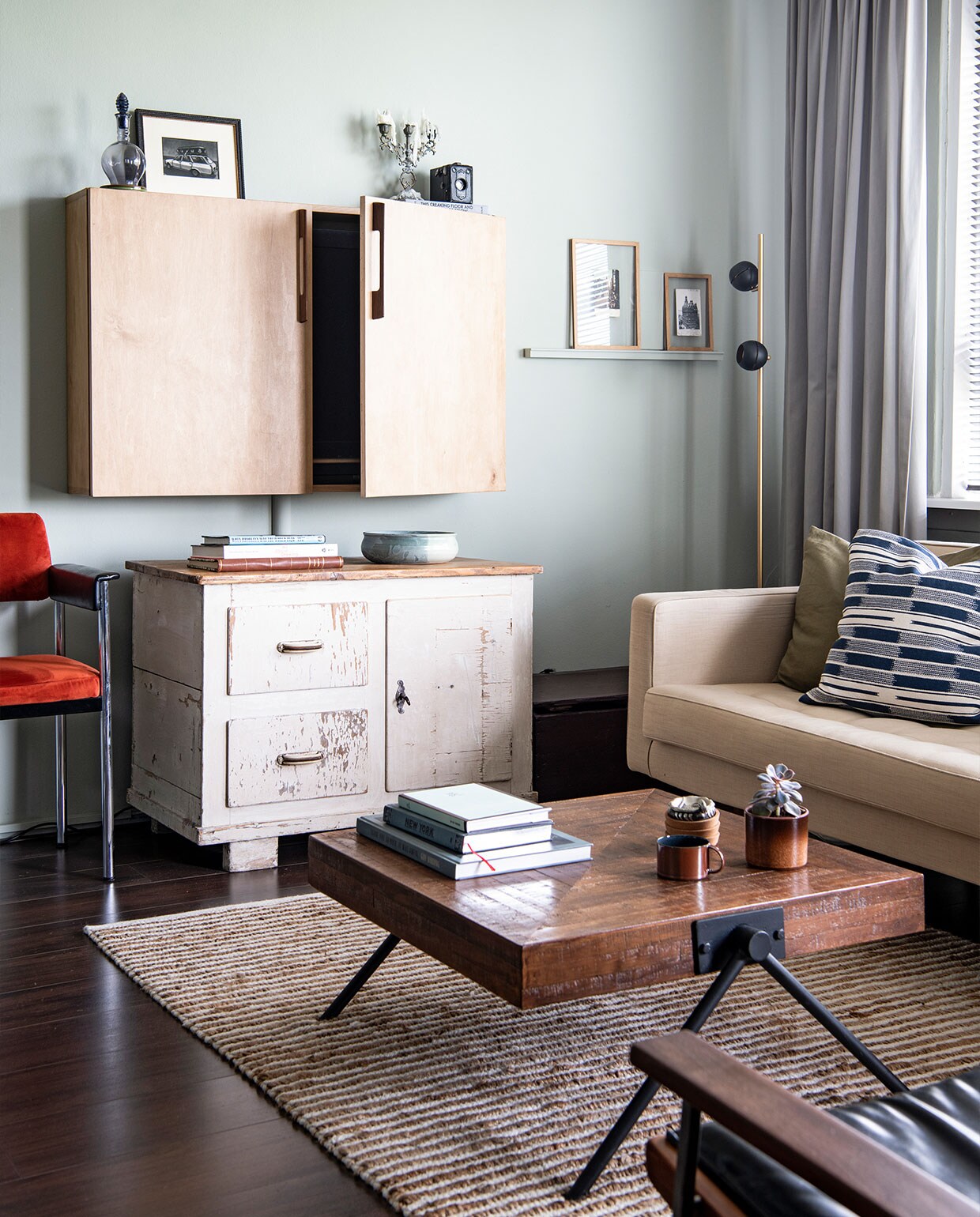 Vloer Ikea, muurverf Mizzle van Farrow &amp; Ball. Oranje stoel cadeau, vloerkleed Zara Home, televisiekast zelfgemaakt met grepen van Woodchuck, kast en kandelaar vintage, karaf erfstuk, kom souvenir, ingelijste mezzotint van Sjoerd Tegelaers. Bank Loods 5, kussens H&amp;M Home, vloerlamp Leen Bakker, bijzettafel cadeau, vazen en pot erfstukken, koffie­tafel boeken Thank you so much. It was awful van Guy Vording, New York van Hannibal Books, Most People Are Idiots van Guy Vording, gordijnen Hema.