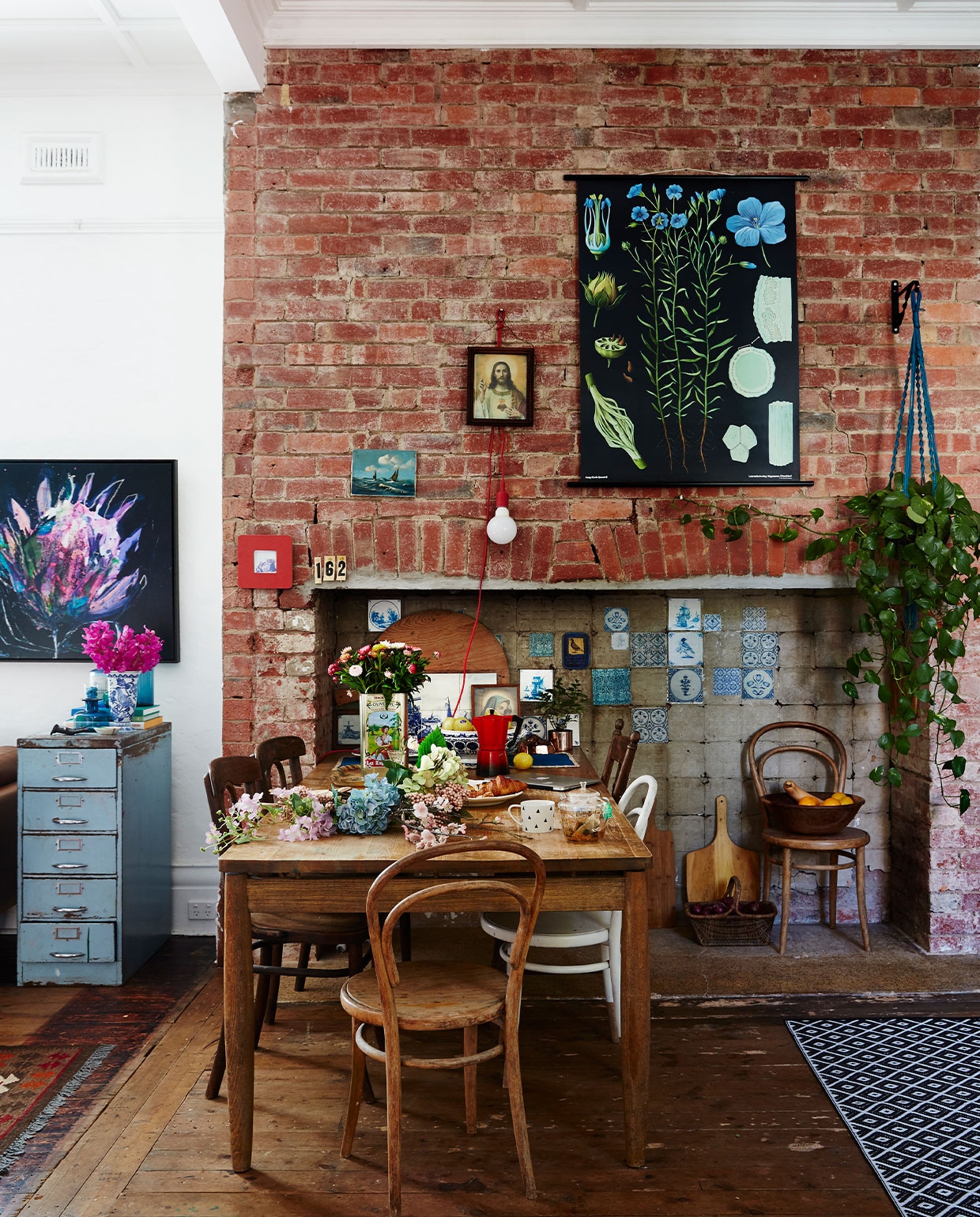 Hangplant en zwarte biologieposter Casa Verde Flowers. Delftsblauwe tegels, meubels, decoraties en accessoires vintage. Lamp Kikkerland.