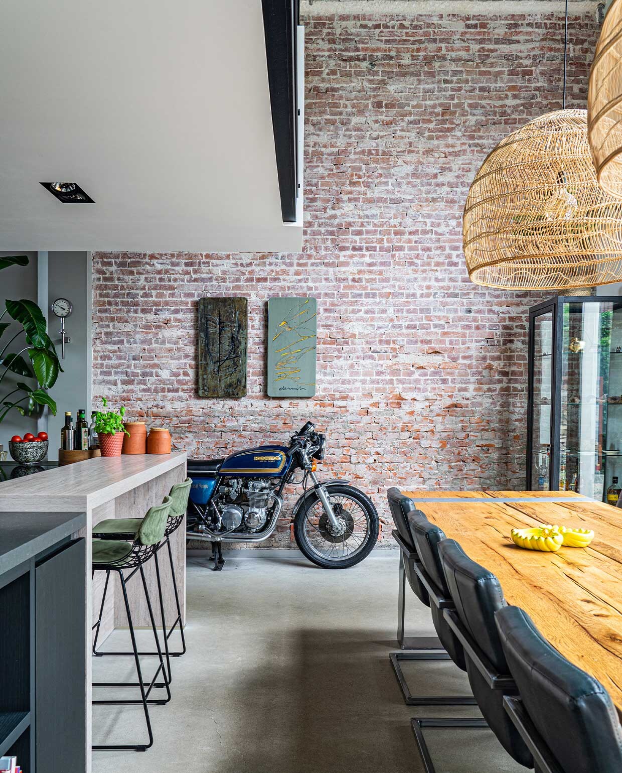 Eettafel Iccoon, stoelen van een veiling, lampen en barkrukken HKliving, kunst Wiegen den Uyl, motor Honda, bar Piet Boon Kitchen. Op tafel bananenschaaltjes Tigerwoods. Potten op bar Made, overig onbekend.