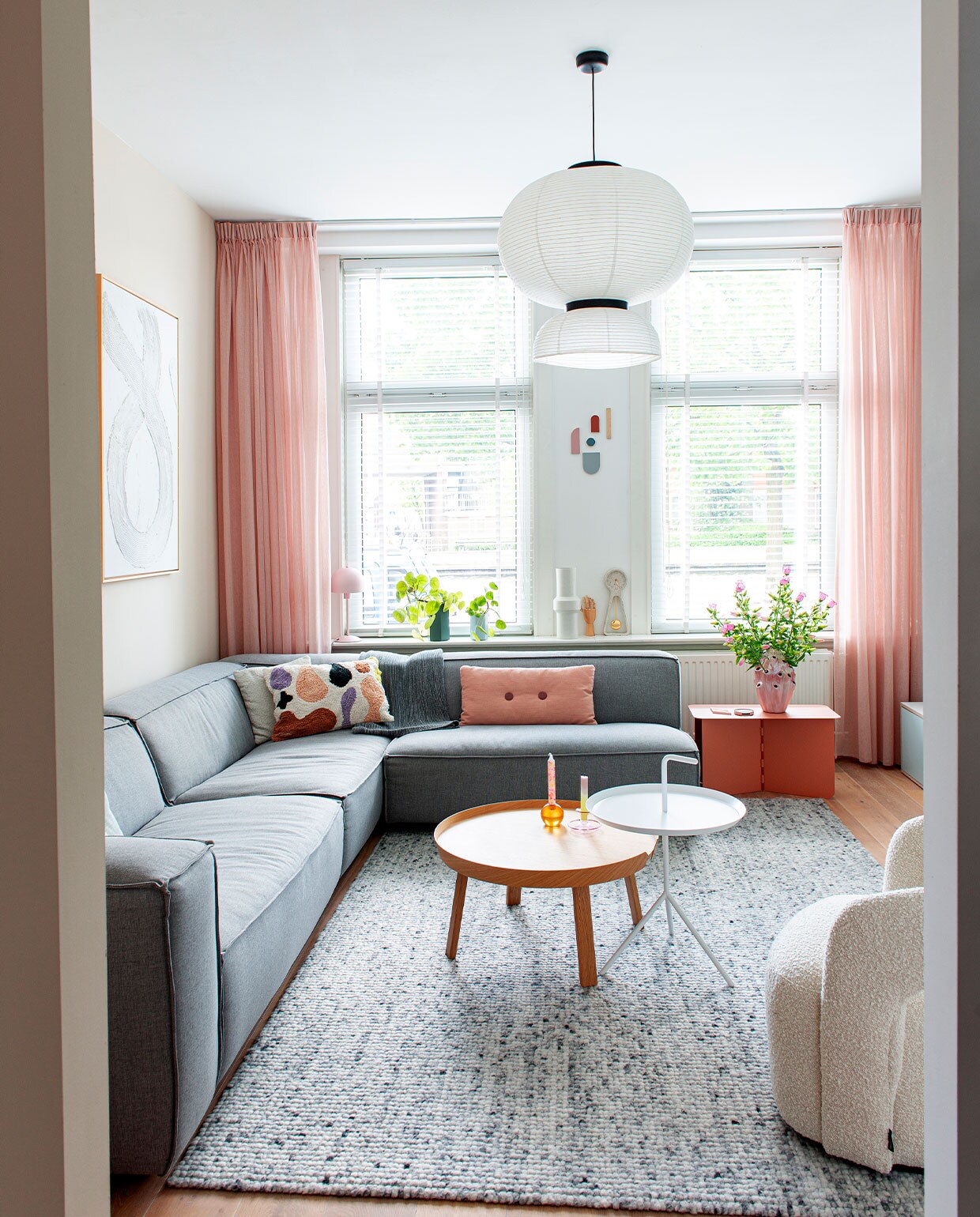 Hoekbank Dunbar Fest Amsterdam via Wonenmetlef. Roze kussen Hay, overige kussens Sissy-Boy Homeland. Roze bijzettafel Puik Design. Vloerkleed Floorpassion. Houten bijzettafel Muuto. Witte bijzettafel Hay. Hanglamp &amp;Tradition. Fauteuil Sofa Company. Schilderij zelfgemaakt. Gordijnen Tulay in Rotterdam. Groene en blauwe vazen Ferm Living. Witte vaas HKliving. Klok Zuiver. Overig onbekend.