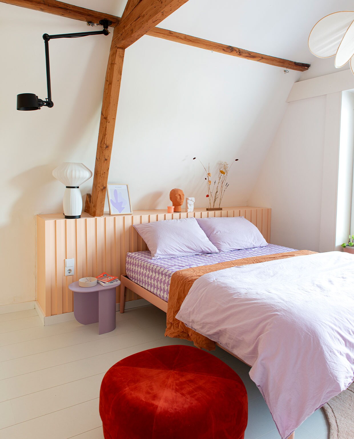 Wit laminaat Douwes Dekker. Kleur bedhoofd Mexico van Gamma. Zwarte hanglamp Tonone. Witte tafellamp Kwantum. Illustratie Melissa van Roon, MVR Desig. Oranje hoofd HKliving en bijzettafel Plateau van Fest Amsterdam via Wonenmetlef. Schaaltje Dixon Fest Amsterdam. Bed Auping. Hoeslaken Swedish Linen. Lila dekbedovertrek Ikea, bruin dekbedovertrek Zara Home. Poef Circus Normann Copenhagen. Overig onbekend.