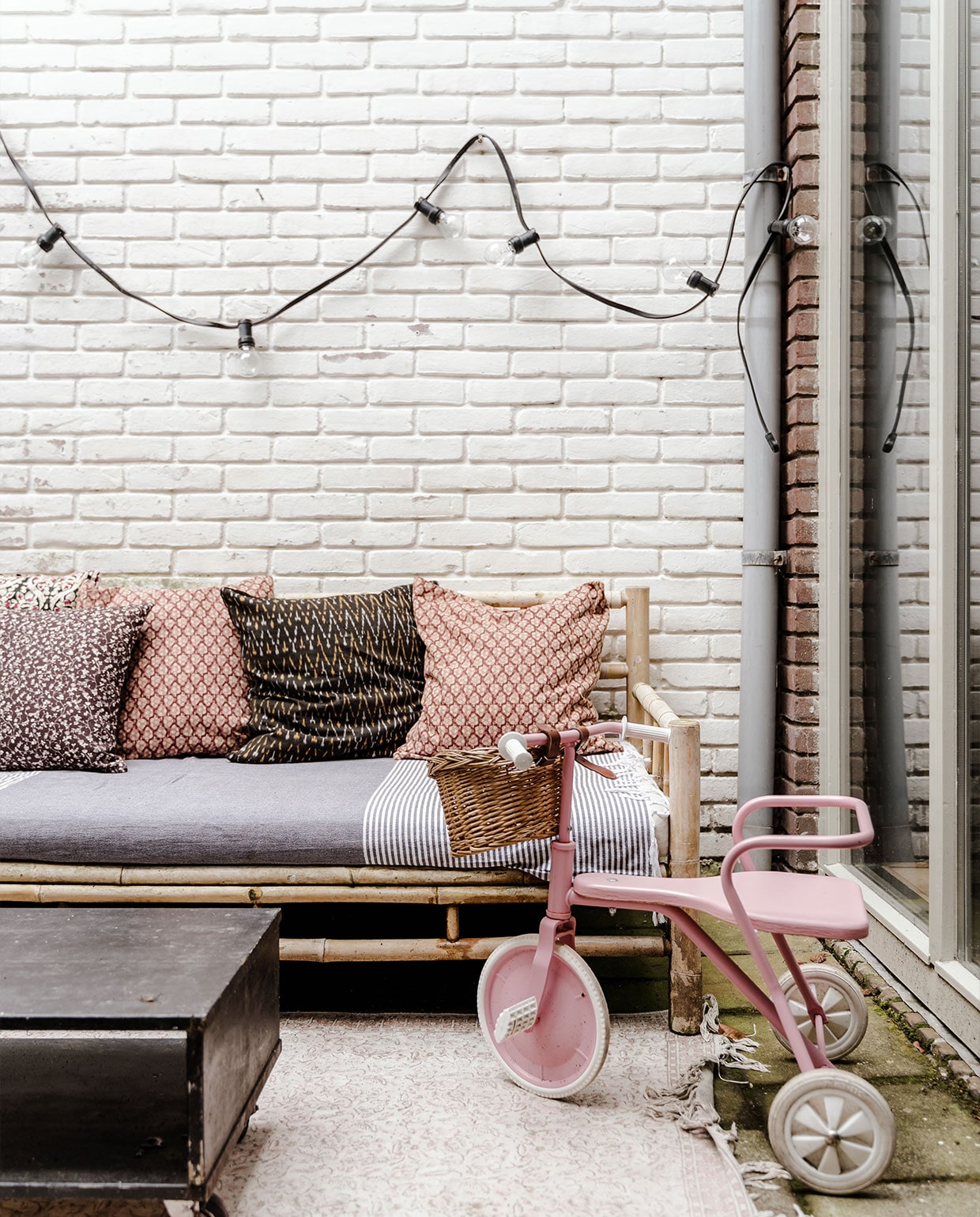 Vloerkleed Dutchbone via Loods 5, zetel Wehkamp, kussens Madam Stolz, Meri-Lou en Sissy-Boy, hamamdoek Sissy-Boy, fiets Foxrider, tafel zelfgemaakt, lichtsnoer onbekend.