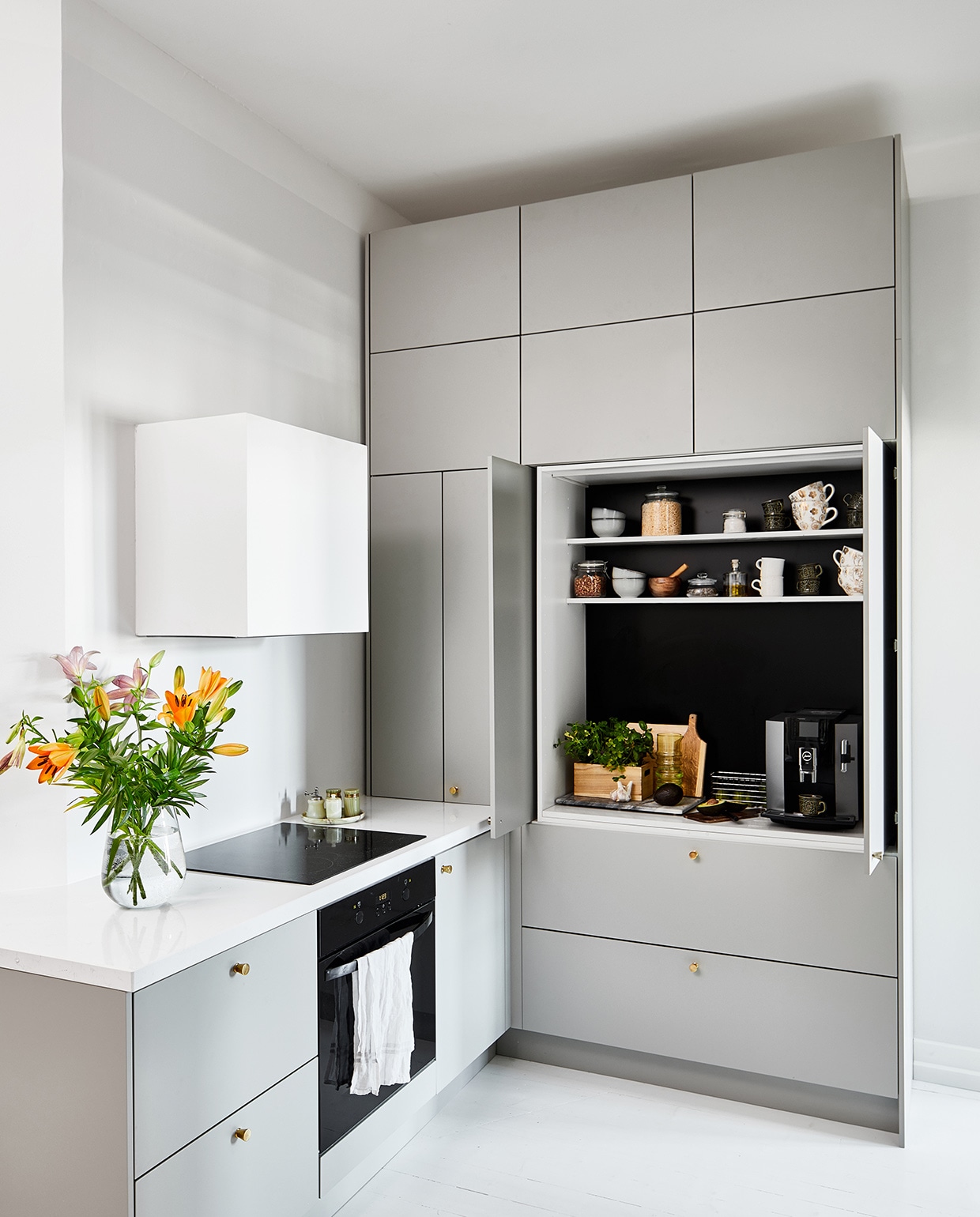 Keuken met inschuifdeuren op maat gemaakt door Blau Interior, geverfd in kleur ON.00.76 van Flexa. De houten vloer is wit geverfd.