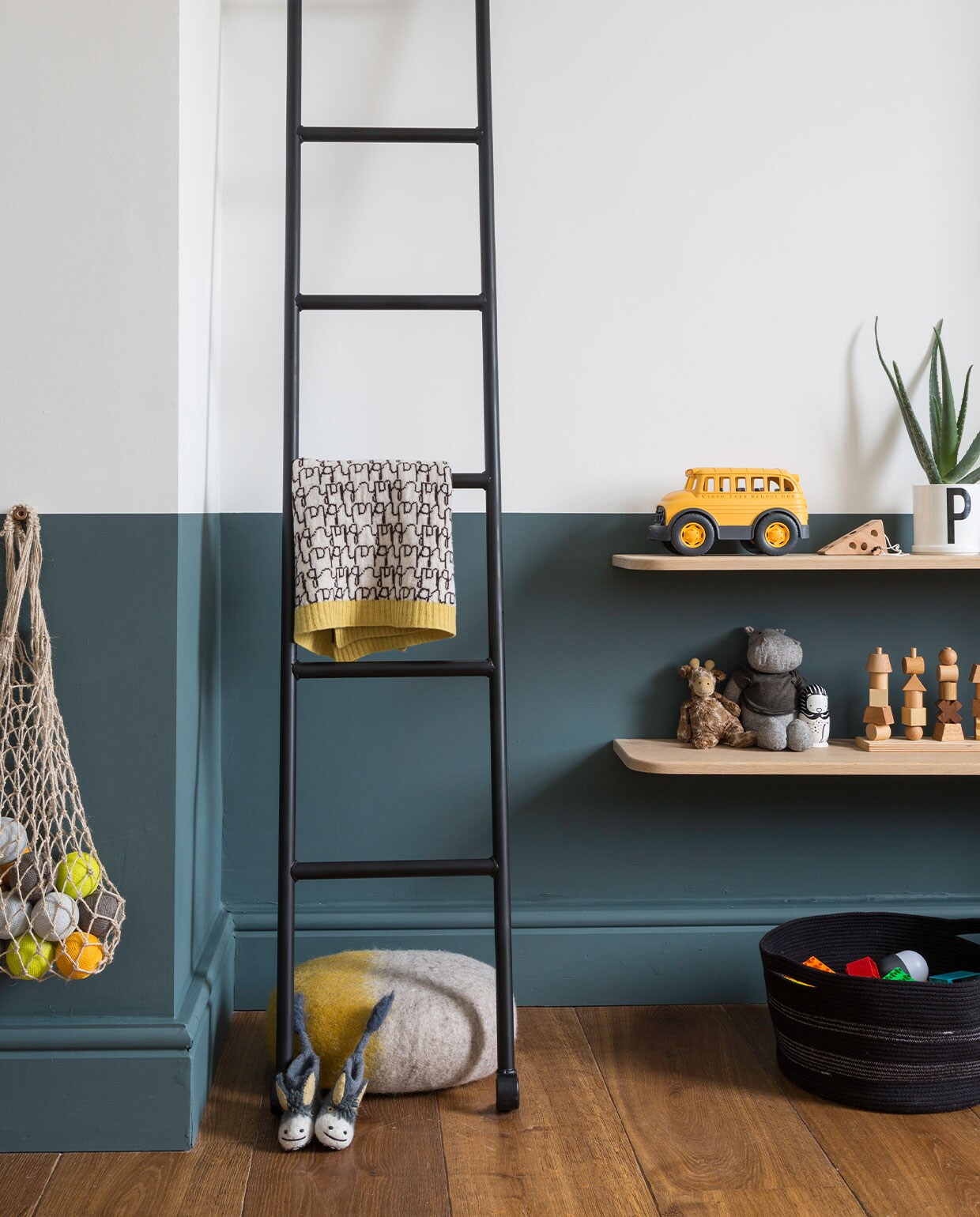 Ladder uit gymzaal, zelf zwart gespoten. Deken Donna Wilson, poef Muskhane. Sloffen Sew Heart Felt. Plantenpot met letter P Design Letters. Houten stapelspel Wooden Story. Overig onbekend.