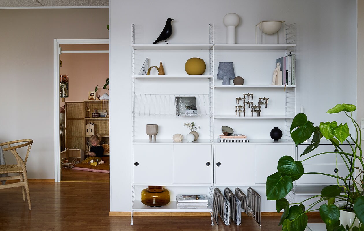 Wandrek String. Vogel Vitra. Beelden Kristina Dam Studio. Kandelaar Stoff Nagel. Vazen en kommen Cooee. Tijdschriftenrek op vloer Aytm. Stoel van Hans Wegner via Flinders.