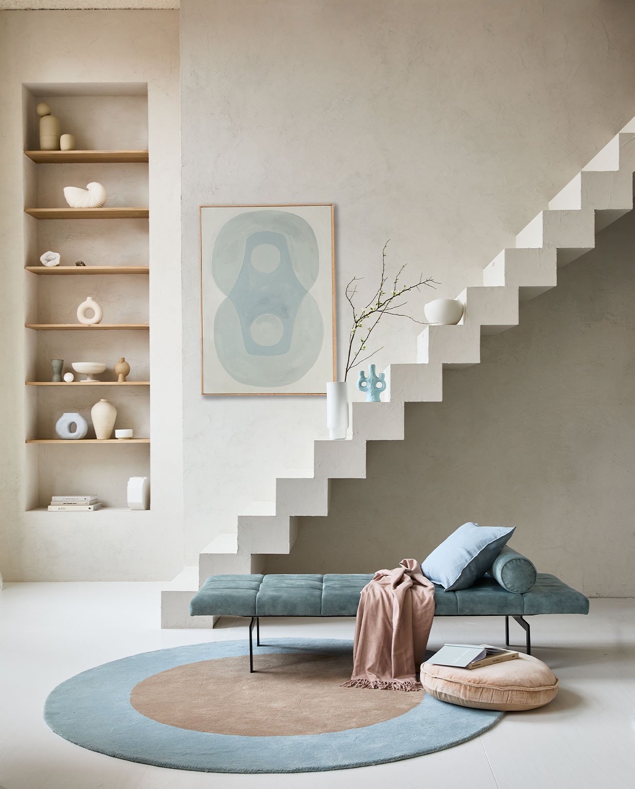 Op de muur kalkverf Fresco Old Flax van Pure &amp; Original, per liter € 55,- (paint-pure.nl). Daybed Alfies in Faded Blue, 190x70x38 cm (bxdxh) vanaf € 828,- (versmissen.nl). Schilderij Longing for, acryl op canvas van Anne Olde Kalter, 70×100 cm prijs op aanvraag (anneoldekalter.com). Rond vloerkleed Dot, 200 cm (Ø) € 699,- (festamsterdam.com). Rond fluwelen zitkussen van HKliving, 60 cm (Ø) € 55,99. Vaas Shell Pot van Ferm Living € 99,-, vaas Forma large van Bolia € 90,- (vtwonen.be). Lichtblauwe kandelaar van &amp;Klevering € 35,- (groenenakker.nl). Witte kom op trap € 39,99 (zarahome.com). Vazen met bol erop op bovenste plank prijs op aanvraag (byjoa.nl). Witte vaas cirkel € 14,99 (hm.com). Vaas van 101CPH op tweede plank € 39,- (debijenkorf.nl). Schaal op voet € 59,95 (urbannatureculture.nl). Overig privébezit.
