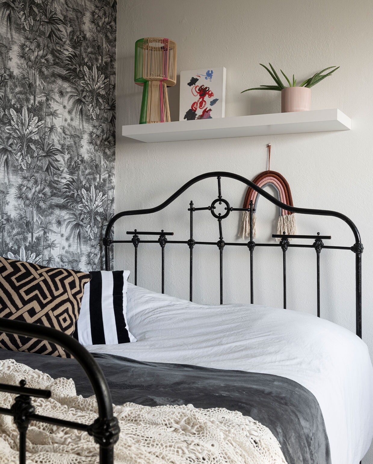 Behang en regenbooghanger Kwantum. Bed uit het ouderlijk huis van Noor. Gestreept kussen HKliving, geometrisch kussen Alaloes Object &amp; Interieur. Gehaakte sprei gemaakt door Noors oma. Draadlamp Kitsch Kitchen.